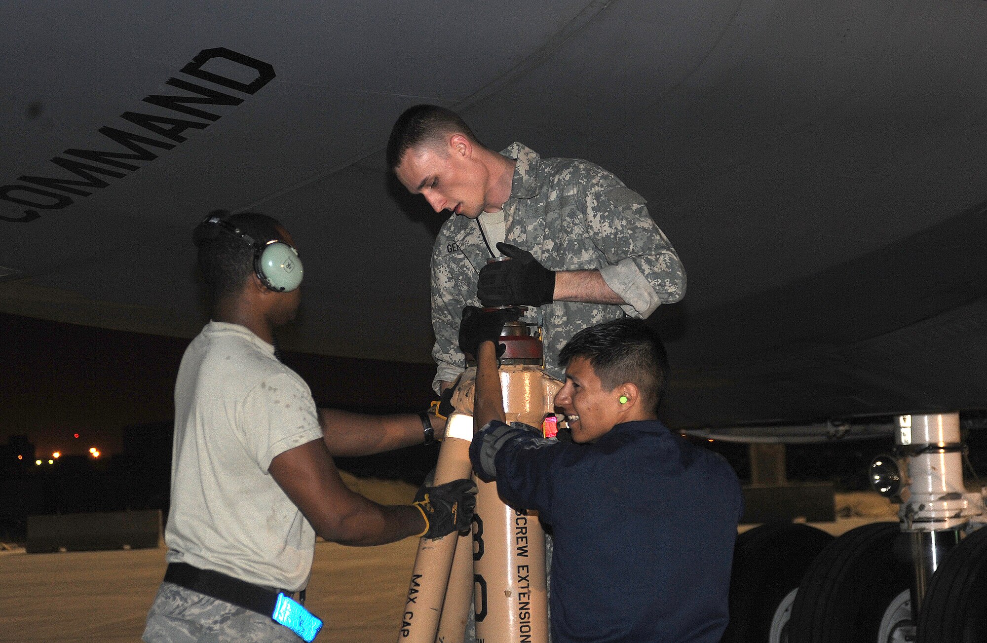 Senior Airmen Jon Kirk, Dan Gerstner and Staff Sgt. David Rosas, position a jack stand on a C-5 Galaxy on the flightline of this deployed location in Southwest Asia, April 7. (U.S. Air Force photo/Staff Sgt. Liliana Moreno)                       