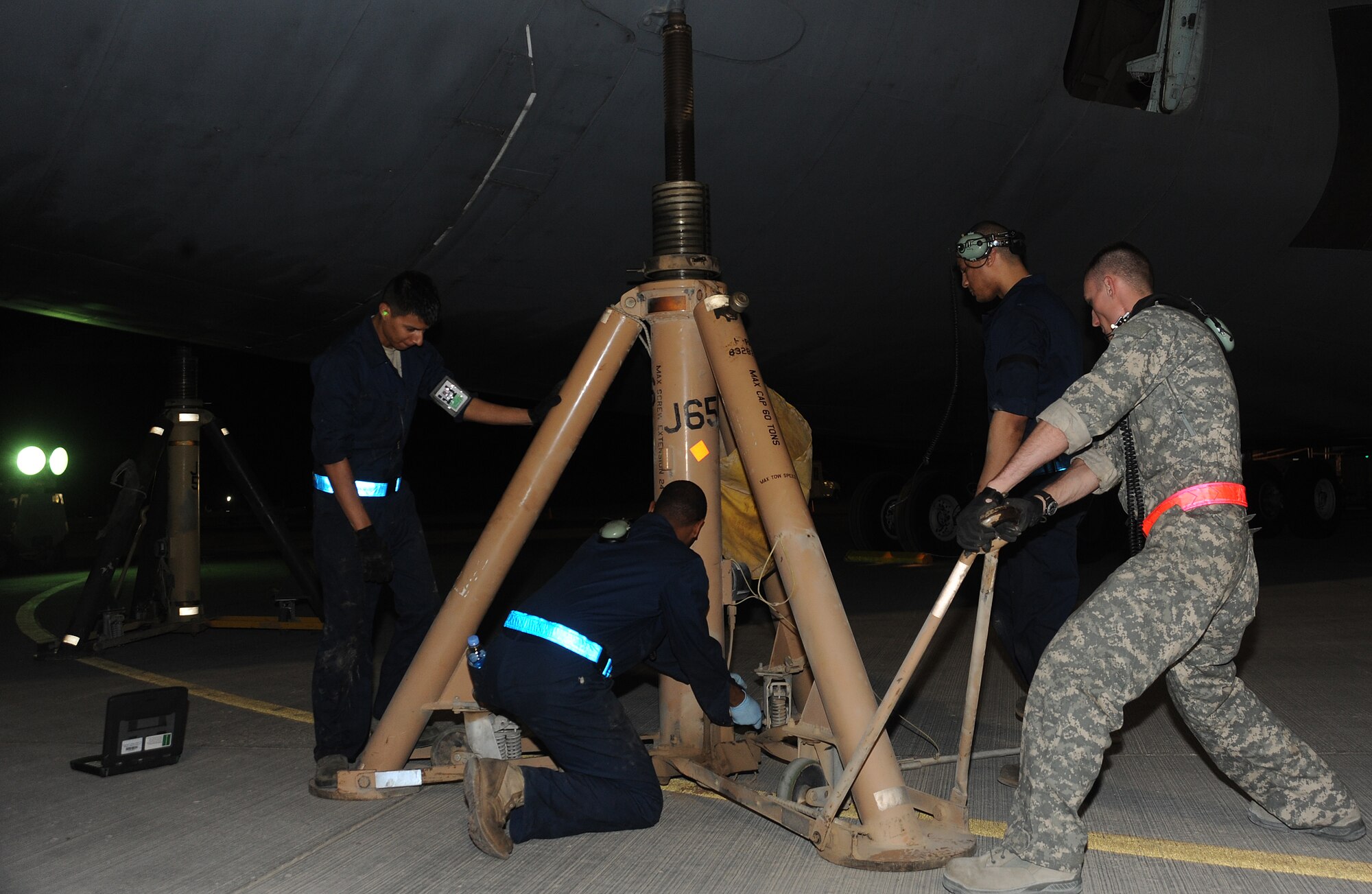 Deployed Airmen position a jack stand under a C-5 galaxy aircraft to perform an operational check on the main landing gear, April 7. The Airmen are deployed to an air base in Southwest Asia.  (U.S. Air Force photo/Staff Sgt. Liliana Moreno)          