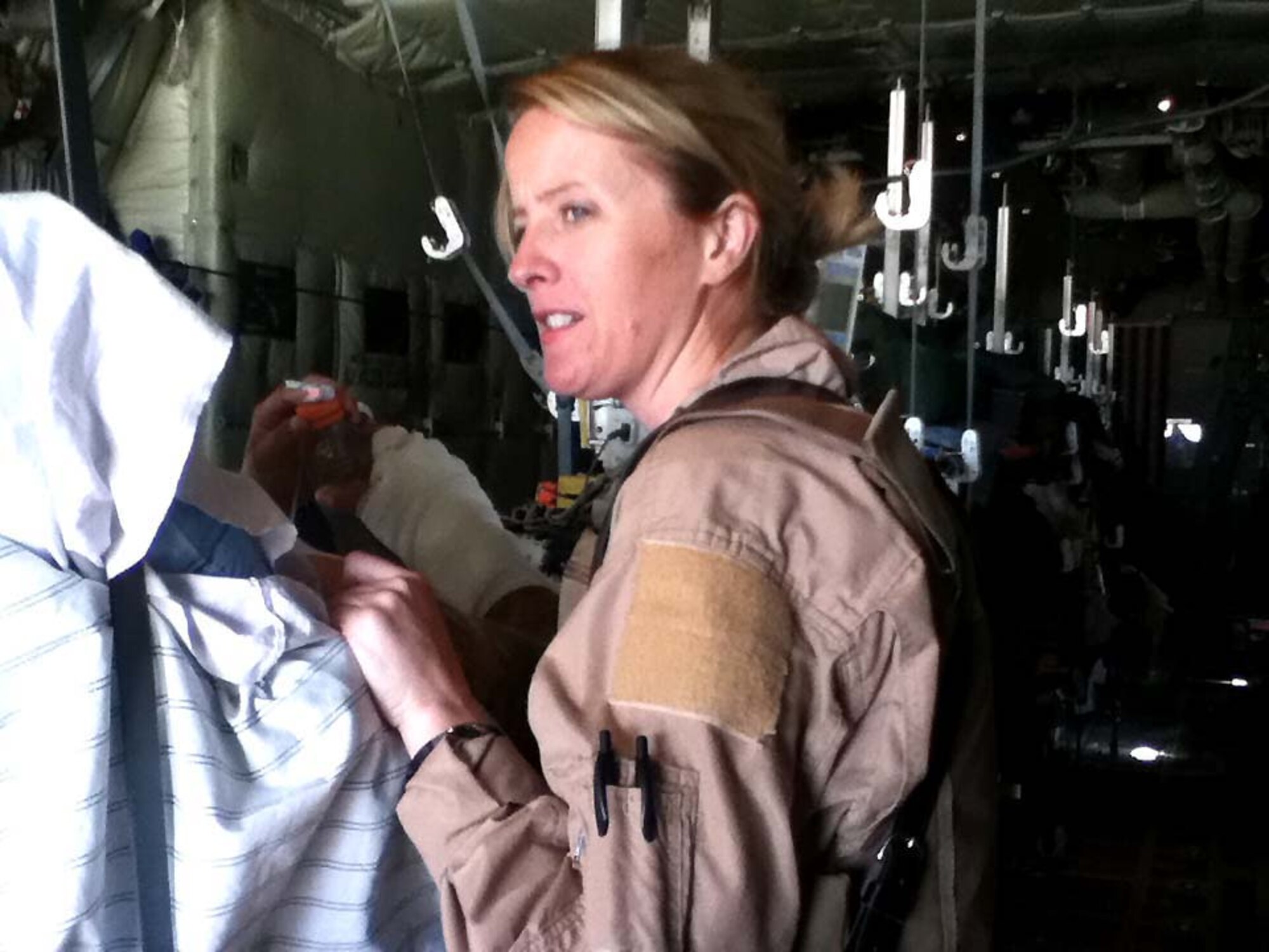 Technical Sgt. Nicole Costigan comforts her patient after he was loaded onto a C-130 at Kandahar Airfield April 6. She is a respiratory technician assigned to the 451st EAES at KAF and cares for critically wounded patients as they are flown out of the airfield.