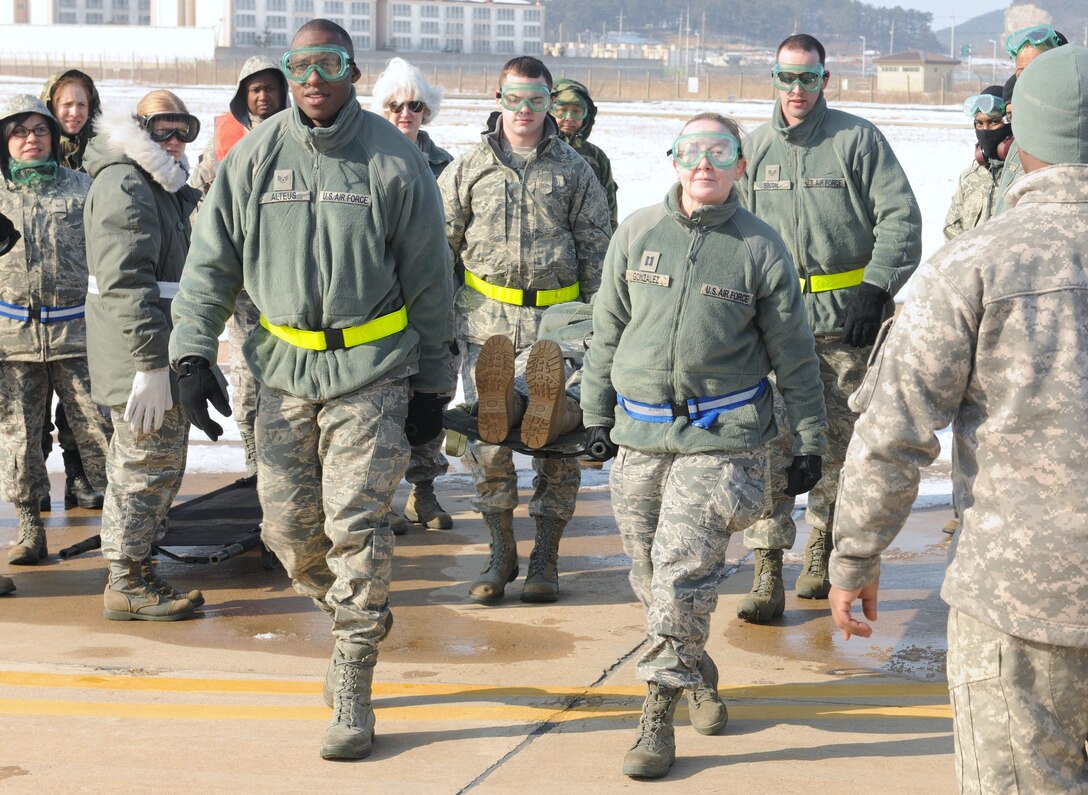 KUNSAN AIR BASE, Republic of Korea -- Members from the 8th Medical Group carry a simulated patient during a recent training exercise. When transporting patients on a litter, position manpower evenly on both sides of the litter and ensure the person to the right of the patient’s head calls commands. (U.S. Air Force photo/Senior Airman Ciara Wymbs)