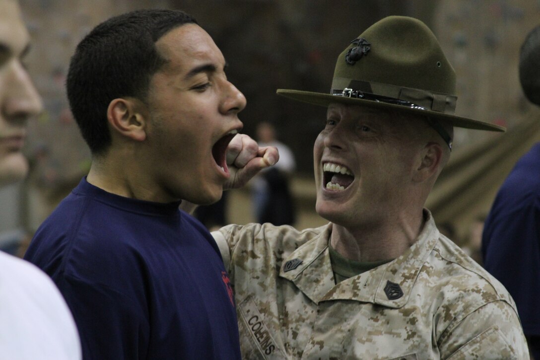 Gunnery Sgt. Phillip H. Collins, a drill instructor at the United States Naval Academy,  provides some extra motivation to a poolee from Recruiting Station Baltimore April 9. Drill instructors gave poolees a preview of what awaits them in recruit training with an intense physical training session during the RS’s annual field meet.