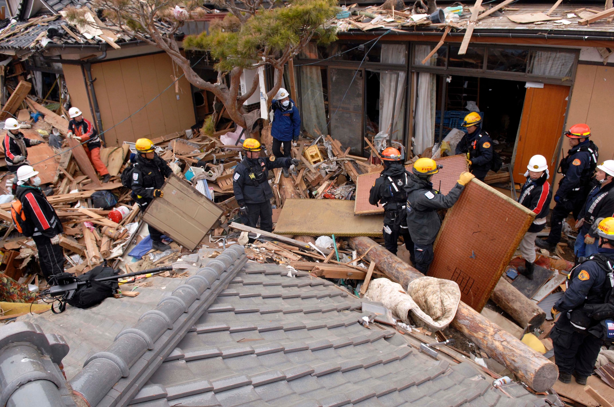 Members of the The Los Angeles County Fire Urban Search and Rescue Team, Task Force 2, who travelled with the 452nd Air Mobility Wing, March Air Reserve Base, Calif., to the earthquake and tsunami stricken areas of Japan just four days after the devastation, search through rubble with their Japanese counterparts.  (U.S. Air Force photo/Technical Sgt. Daniel St. Pierre)