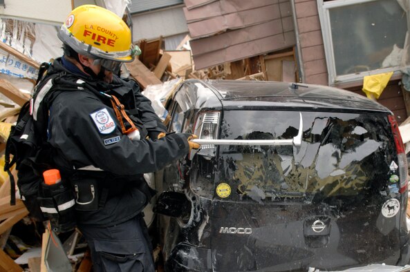 Firefighter Gamble, CA-TF2 breaks a window of a car to search it for tsunami victims in Ofunato, Japan on March 15, 2011. The Los Angeles County Fire Urban Search and Rescue Team, Task Force 2, travelled with the 452nd Air Mobility Wing, March Air Reserve Base, Calif., to the earthquake and tsunami stricken areas of Japan just four days after the devastation.  (U.S. Air Force photo/Technical Sgt. Daniel St. Pierre)