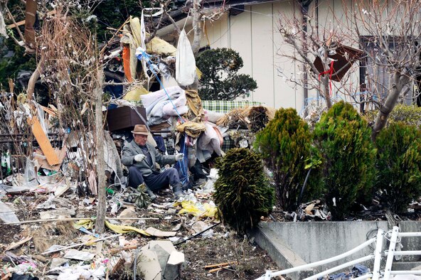 A Japanese man sifts through the aftermath of the deadly tsunami that ripped through his city days earlier.  The Los Angeles County Fire Urban Search and Rescue Team, Task Force 2, travelled with the 452nd Air Mobility Wing, March Air Reserve Base, Calif., to the earthquake and tsunami stricken areas of Japan just four days after the devastation.  (U.S. Air Force photo/Technical Sgt. Daniel St. Pierre)