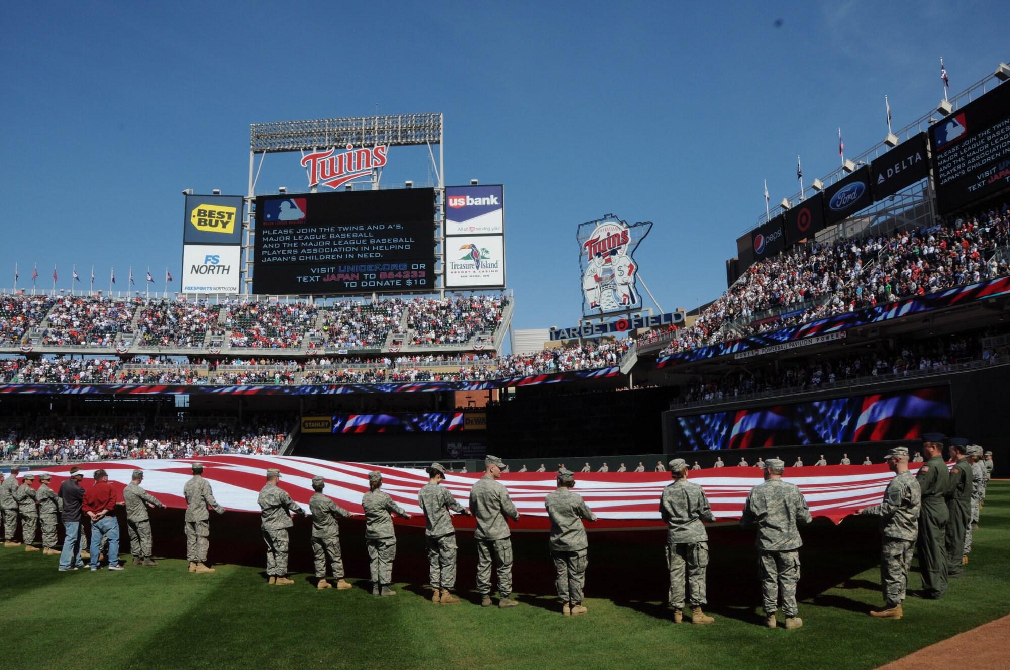 During the Minnesota Twins Home Opener pre-game the stadium was asked to hold a moment of silence for the people of Japan. Members of the Minesota Air National Guard and Minnesota Army National Guard unravel a 1600 pound flag held by over 130 Soldiers and Airmen during the Minnesota Twins home opener April 8, 2011 at Target Field in Minneapolis. USAF official photo by Tech. Sgt. Erik Gudmundson