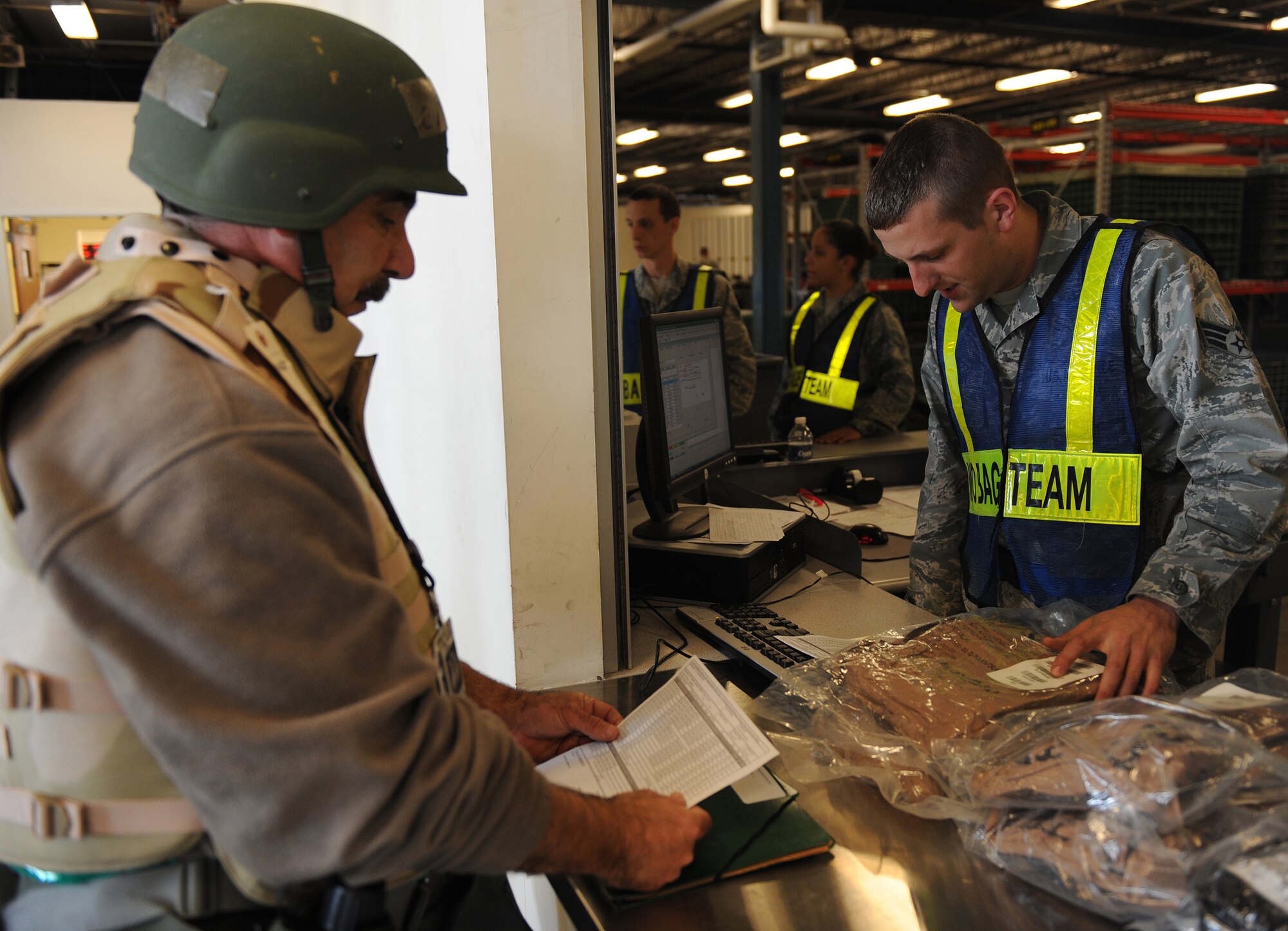 Mr. Daniel Squitieri, 1st Maintenance Squadron Air Force engineer and technical services technician, reviews his checklist as Senior Airman Nicholas Litton, 633d Logistics Readiness Squadron supply technician, issues his equipment during the Operational Readiness Inspection at Langley Air Force Base, Va., April 9, 2011. The inspection is designed to evaluate the ability of installation personnel to efficiently deploy military members, cargo and equipment while also adjusting to rapidly changing security conditions.(U.S. Air Force photo/Senior Airman Zachary Wolf)