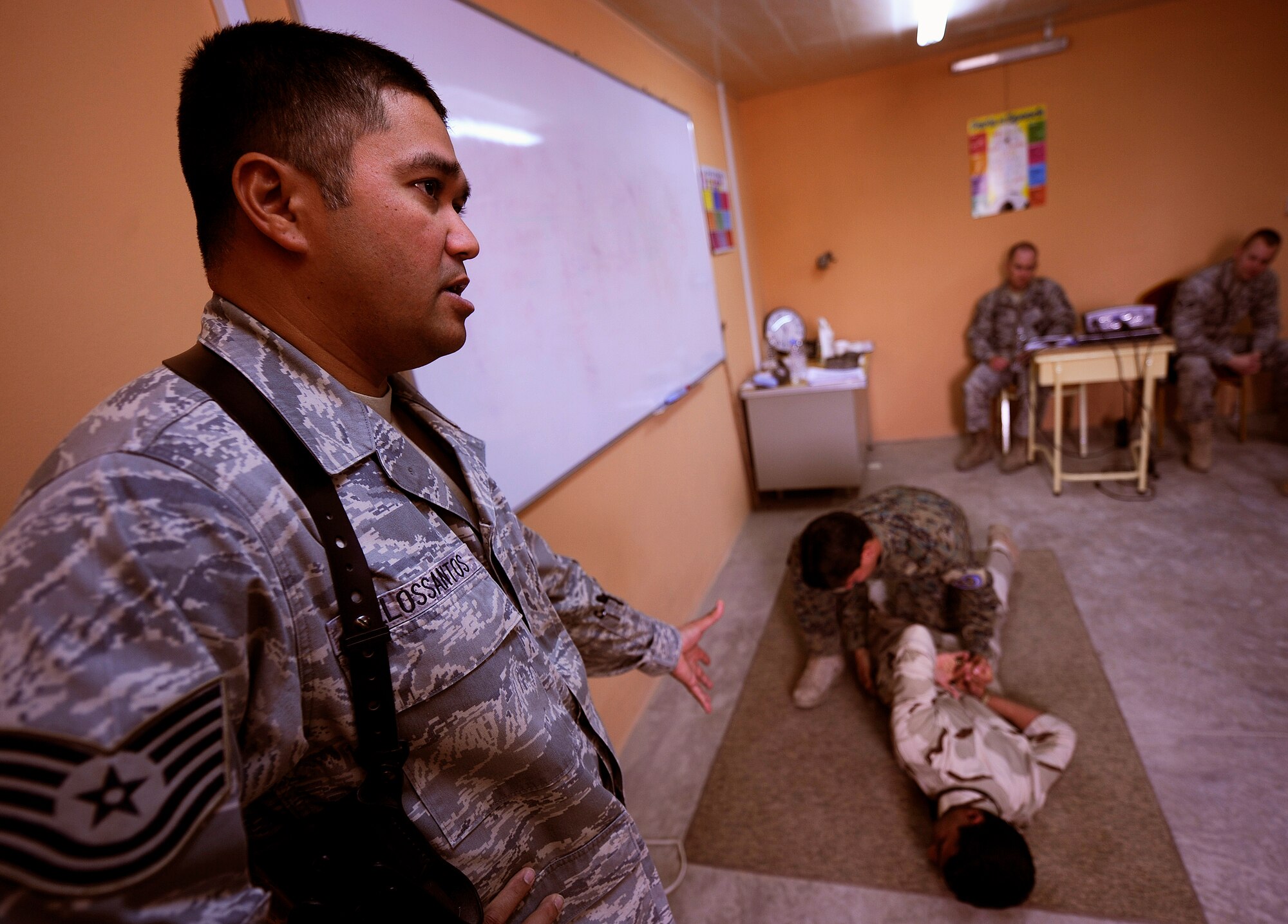 KIRKUK REGIONAL AIR BASE, Iraq -- Tech. Sgt. Daniel Delossantos, 407th Expeditionary Security Forces Squadron, instructs Iraqi air force airmen on how to properly detain a suspect during a two-week security forces course taught by three U.S. Air Force Airmen. More than a dozen Iraqi defenders learned about air base defense tactics before graduating from the course April 7. (U.S. Air Force/Tech. Sgt. Jason Lake)