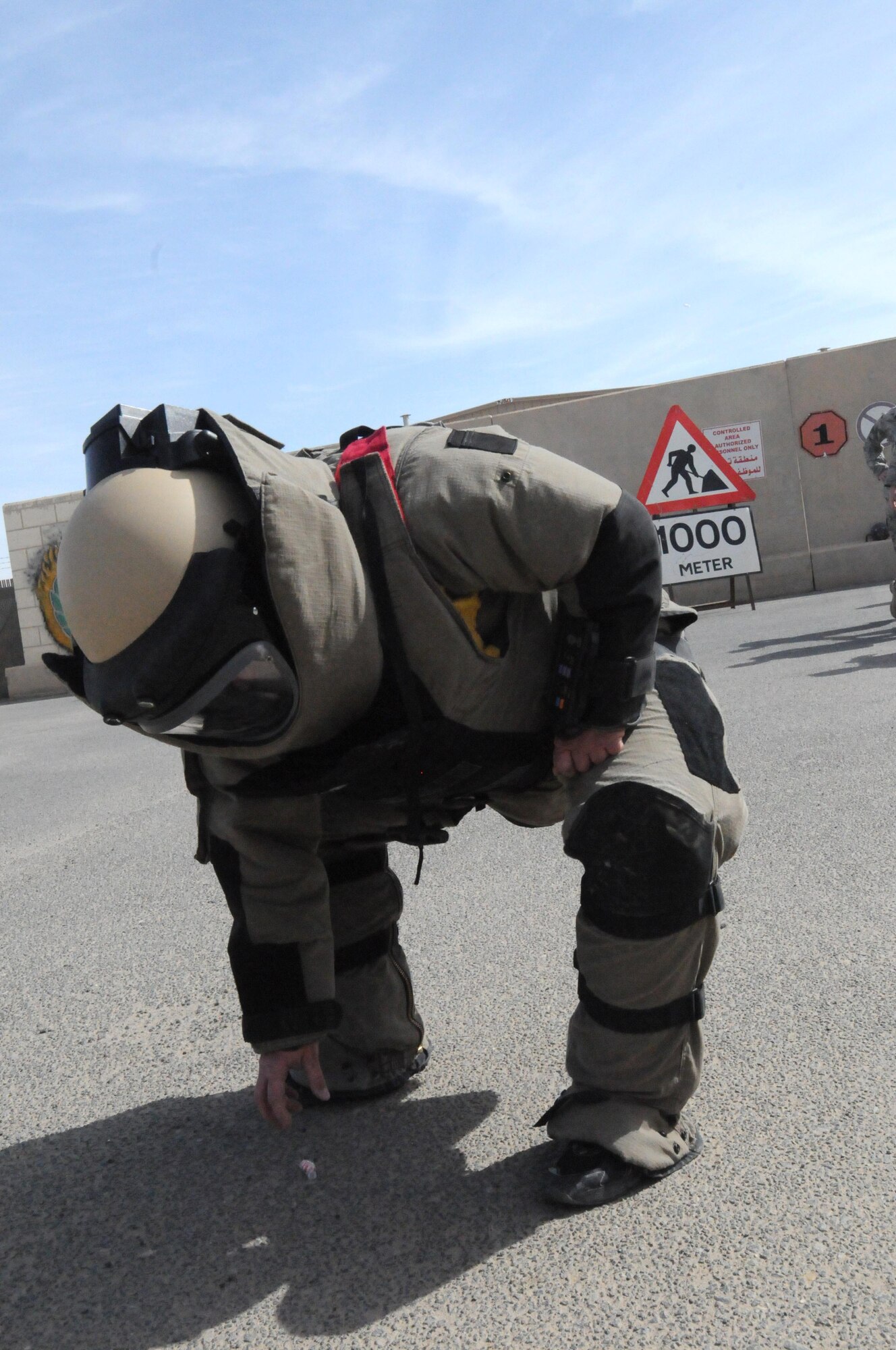 Staff Sgt. Benjamin Cully, a firefighter with the 386th Expeditionary Civil Engineer Squadron, goes to pick up a piece of candy as part of an exercise intended to test mobility and attention to detail in the bomb suit. Sergeant Cully participated in the Rock Top III's Shadow Program which allows enlisted members to shadow senior non-commisioned officers in other career fields. (U.S. Air Force photo by Staff Sgt. Patrice Clarke)