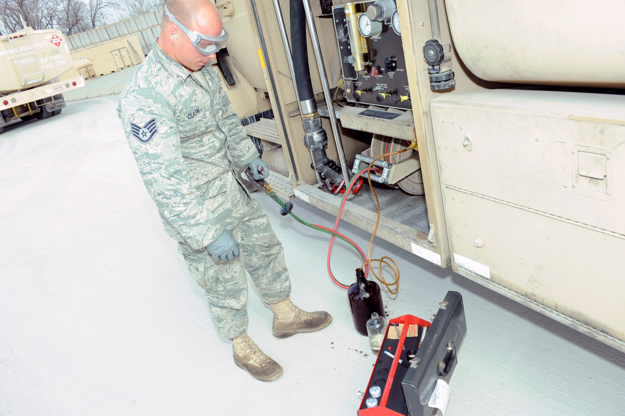 TRANSIT CENTER AT MANAS, Kyrgyzstan - Staff Sgt. Michael Clark, 376th Expeditionary Logistics Readiness Squadron, petroleum, oil and lubricants laboratory and fuels storage technician, draws a fuel sample from an R-11 here April. 1.Sergeant Clark, deployed from the 96th Logistics Readiness Squadron at Eglin AFB, Fla. helped achieve the squadron record, of pumping 587,546 gallons of jet fuel in a 24-hour period back on March 11.  Previously, the 51-person and four Kyrgyz personnel-held record was set February 18 at 544,758 gallons in 24 hours.  (U.S. Air Force photo/Tech. Sgt. Jerome C. Baysmore)