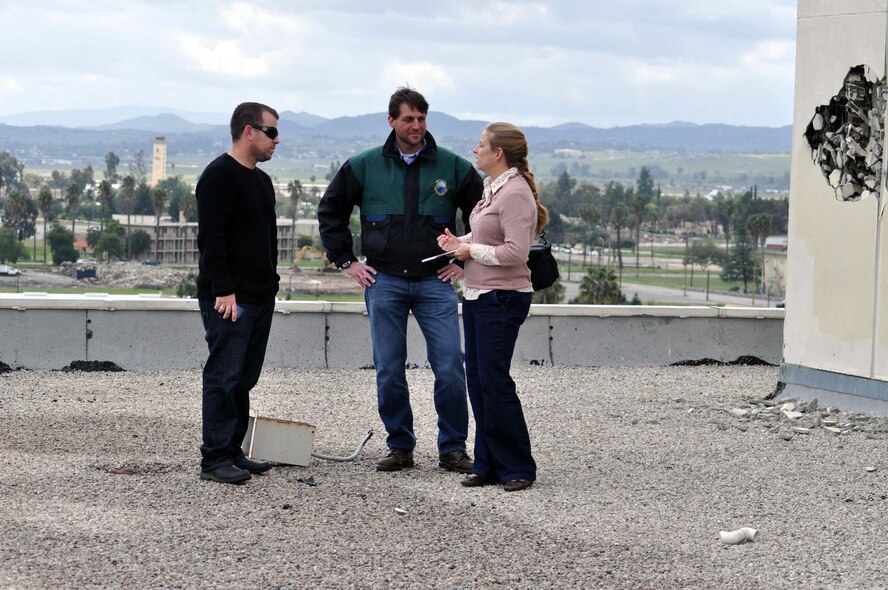 Darren Hughes, Megan Just, Beacon editor, and Robert Miller, Jr, visit the former March Air Force Base hospital building March 27, 2011, just four days before it is scheduled for demolition to make way for March LifeCare medical facilities.  Just interviews Hughes, a former hospital employee and Miller, who was born there, during the visit to the roof.  (U.S. Air Force photo/Linda Welz)