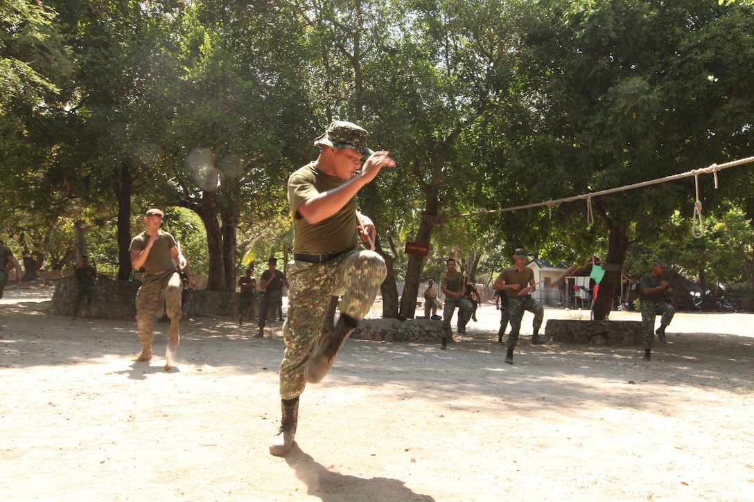 SSgt. Renante Armamento, a martial arts instructor with the Armed Forces of the Philippines Marine Corps, leads U.S. service members in warm-up exercises prior to beginning stick fighting during Balikatan 2011 here April 11. Pekiti Tirsia Kali, the martial art of choice for the AFP, emphasizes quick and evasive movements. Balikatan is an annual bilateral training exercise between U.S. forces and the AFP to maintain operational readiness and strengthen the U.S. and Philippine relationship.