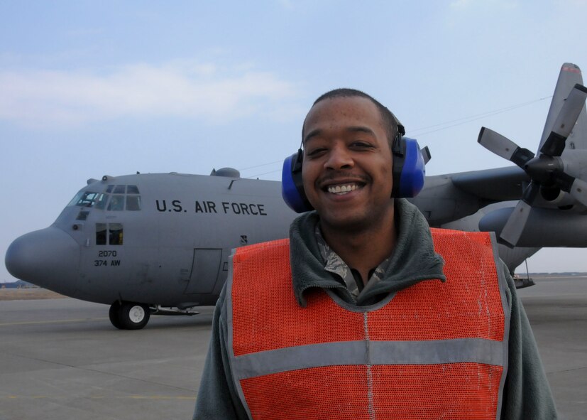 U.S. Air Force Senior Airman TaRon Hodge, a Transient Alert technician with the 35th Maintenance Squadron from Misawa AB, and an Atlanta, Ga.-native, leads a transient C-130 Hercules to its parking spot in support of Operation Tomodachi in Aomori Prefecture, Japan on March 30, 2011.