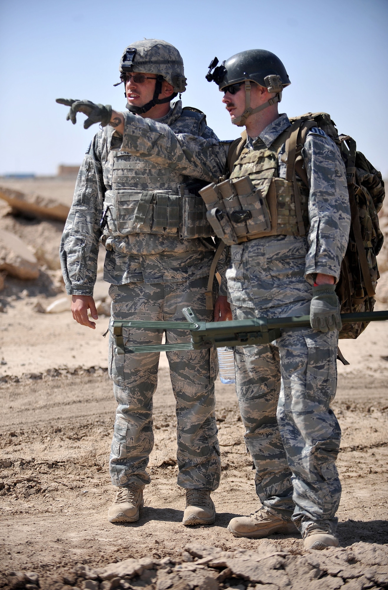 Staff Sgt. Glenn Henthorn, 407th Expeditionary Operations Support Squadron explosive ordnance disposal team chief, points in the distance to show an EOD team member a mock improvised explosive device during a training exercise March 3, 2010, at Ali Air Base, Iraq. (U.S. Air Force photo by Senior Airman Andrew Lee/Released)