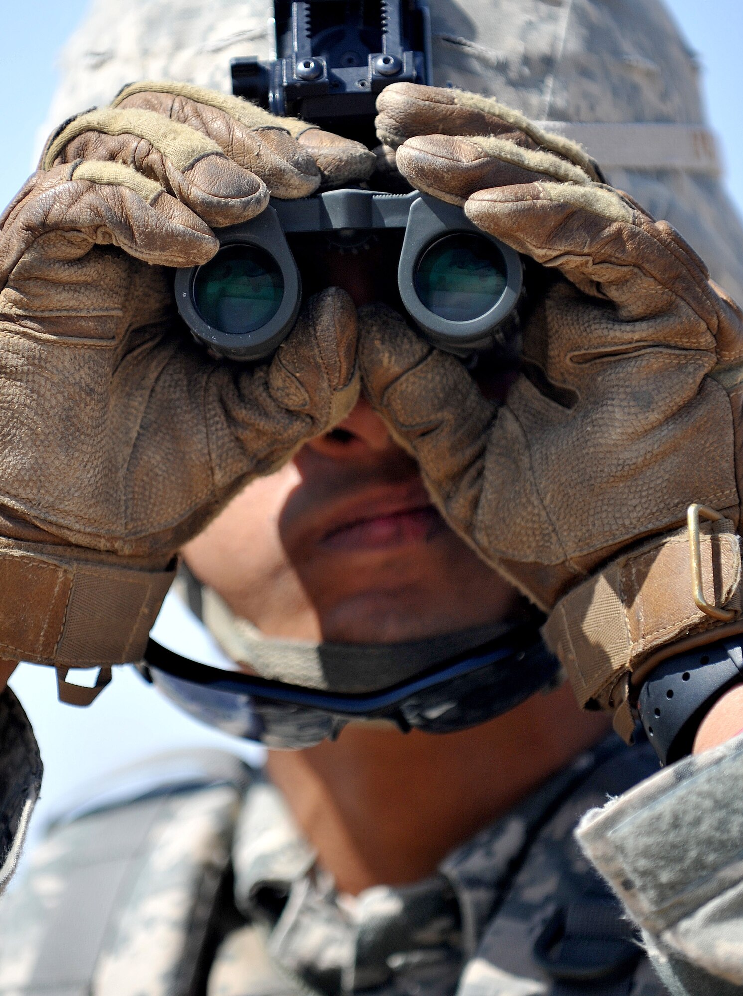 Senior Airman Jesse Mercado, 407th Expeditionary Operations Support Squadron explosive ordnance disposal technician, looks through a pair of binoculars during a training exercise March 3, 2010, at Ali Air Base, Iraq. (U.S. Air Force photo by Senior Airman Andrew Lee/Released)