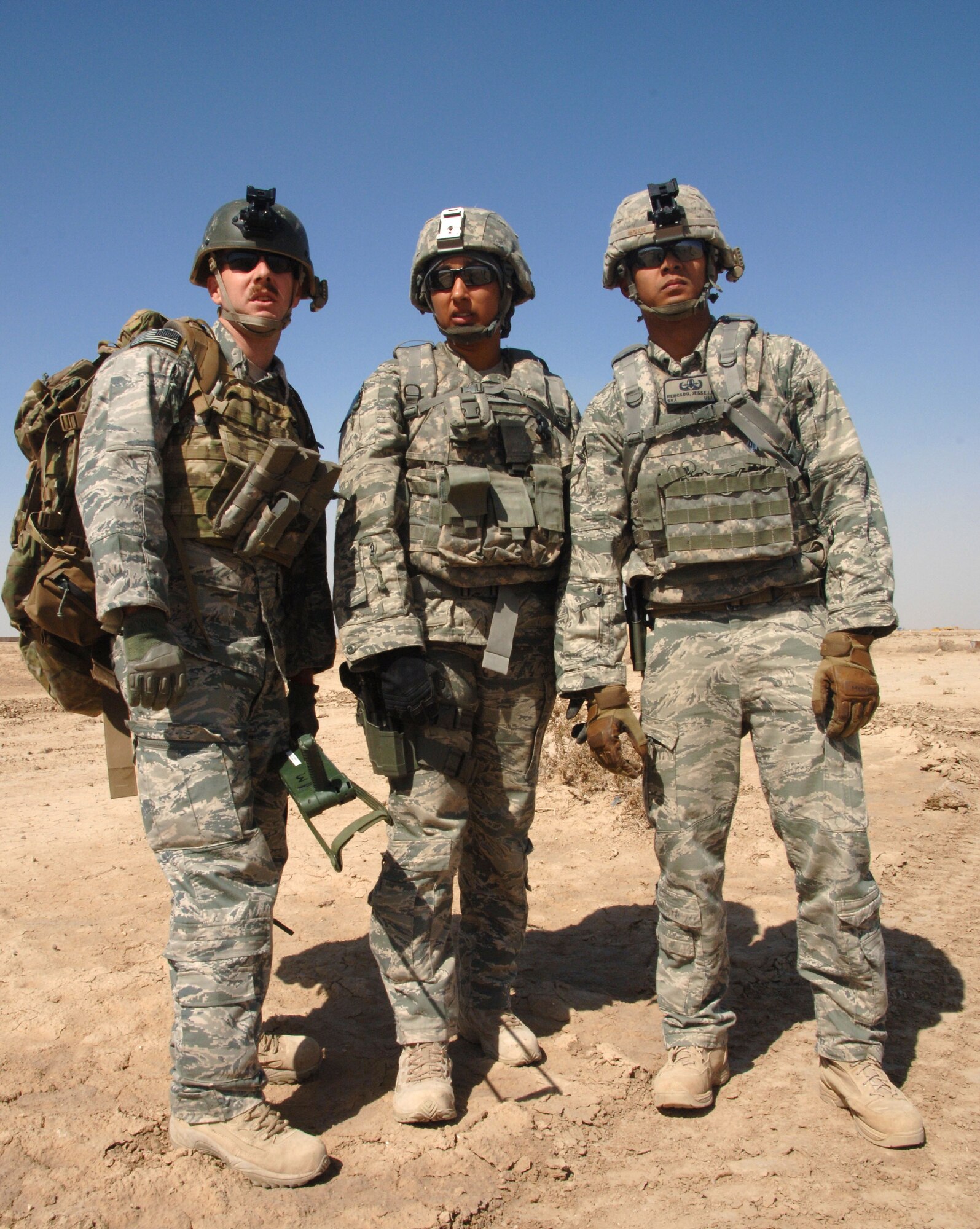 From left to right, Staff Sgt. Glenn Henthorn, Staff Sgt. Christin Merriweather and Senior Airman Jesse Mercado, 407th Expeditionary Operations Support Squadron explosive ordnance disposal technicians, scan a village while discussing a possible hazard during a training scenario March 3, 2011, at Ali Air Base, Iraq. (U.S. Air Force photo by Staff Sgt. R. Michael Longoria/Released)