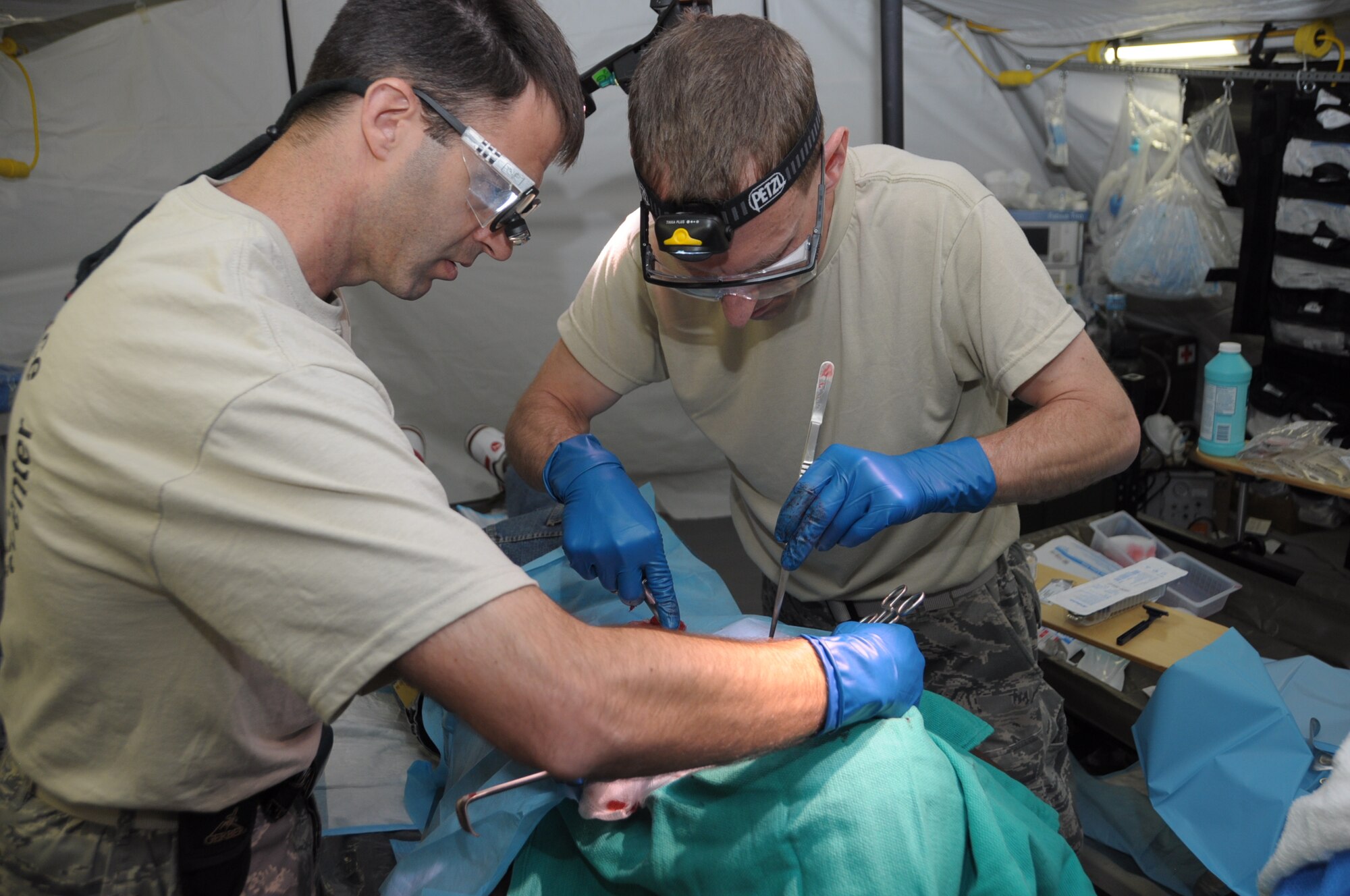 U.S. Air Force Maj. Cale Bonds, 60th Medical Group orthopedic surgeon and Lt Col Mark Scherrer, 60th Medical Group general surgeon extract tissue from a patient at Cumuto Barracks in Trinidad and Tobago April 9, 2011. Bond and Scherrer are members of the Expeditionary Medical Support Health Response Team in support of the Allied Forces Humanitarian Exercise/Fuerzas Aliadas or FA HUM 2011. (U.S. Air Force photo by 2d Lt Joel Banjo-Johnson/Released)
