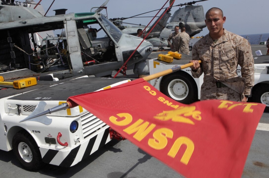 (April 10, 2011) Cpl. Eugene Grover, a multichannel digital wideband transmission equipment operator with Combat Logistics Battalion 13, 13th Marine Expeditionary Unit (MEU), performs the ‘present arms’ drill movement with a guidon during testing for the inaugural Corporal’s Course aboard USS Green Bay (LPD 20), April 10. 13th MEU is deployed with Boxer Amphibious Ready Group as the USCENTCOM Theater Reserve Force, also providing support for maritime security operations and theater security cooperation efforts in the U.S. 5th Fleet area of responsibility. (U.S. Marine Corps photo by Cpl. Christopher O’Quin/Released)