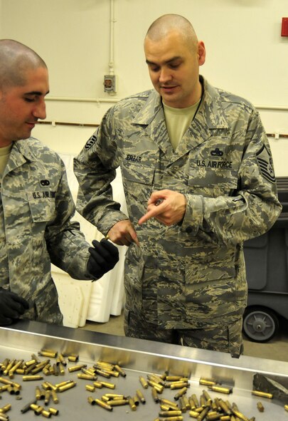 Master Sgt. Frank Erzar, right, 62nd Maintenance Squadron munitions flight superintendent, briefs Staff Sgt. Ryan O’Toole, 62nd MXS munitions storage supervisor, on the importance of identifying and disposing of live rounds April 5 at Joint Base Lewis-McChord, Wash. (U.S. Air Force photo/Airman 1st Class Leah Young)