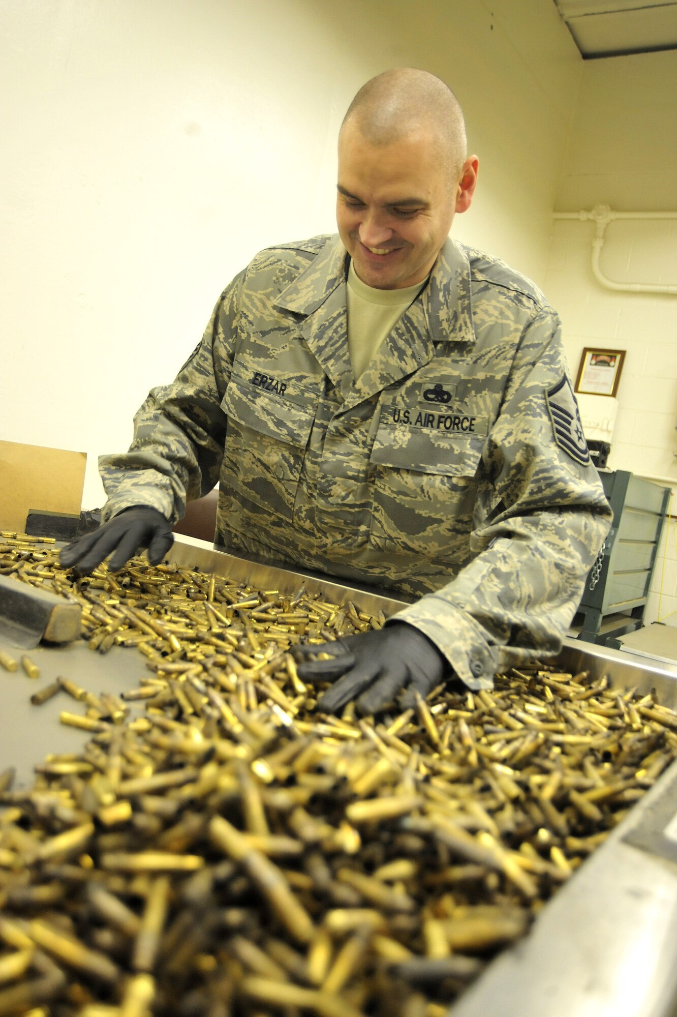 Master Sgt. Frank Erzar, 62nd Maintenance Squadron munitions flight superintendent, sorts through expended small arms April 5 at Joint Base Lewis-McChord, Wash. The munitions flight carefully sorts through the brass, which comes from the firing range, in search of live rounds to make sure they are disposed of appropriately. (U.S. Air Force photo/Airman 1st Class Leah Young)