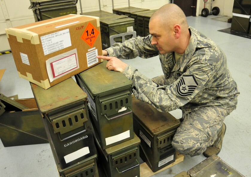 Master Sgt. Frank Erzar, 62nd Maintenance Squadron munitions flight superintendent, reads the label on a box of impulse charges April 5 at Joint Base Lewis-McChord, Wash. The charges are what make the flares fire. (U.S. Air Force photo/Airman 1st Class Leah Young)