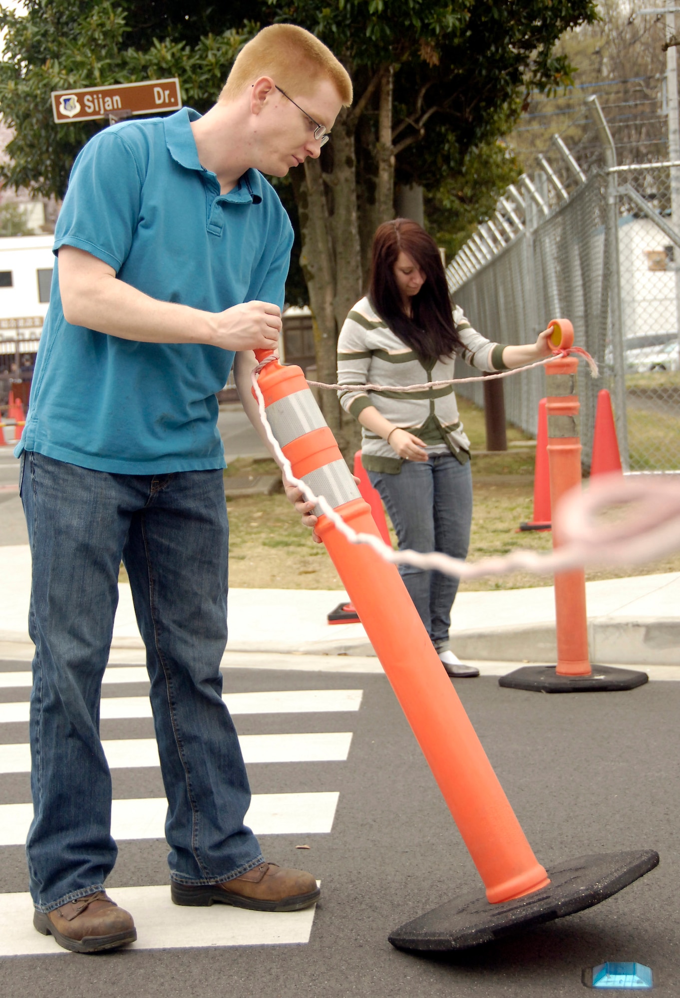 Senior Airman Alexander Barnes and Airman 1st Class Daniella Koza set up guides prior to the Yokota Cherry Blossom Open House April 10, 2011. Base officials opened the gates to the public, allowing the local Japanese community to come on to Yokota to see the trees in full bloom. Airmen Barnes is from Det. 2, Air Postal Squadron; Airman Koza is from the 374th Medical Support Squadron. (U.S. Air Force photo/Staff Sgt. J.G. Buzanowski)