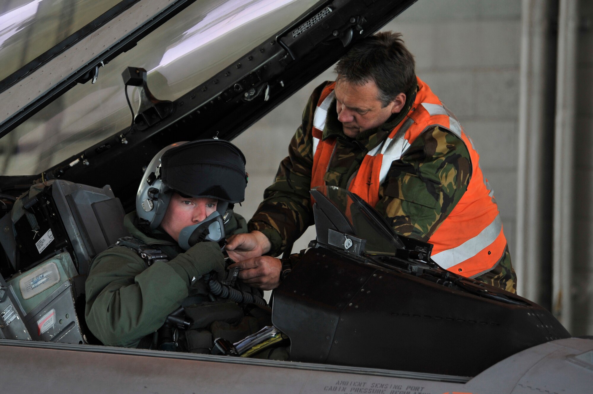 A Royal Netherlands air force crew chief provides assistance to an F-16A pilot prior to a sortie at Eielson Air Force Base, Alaska, April 8, 2011. The RNLAF will be participating in exercises DISTANT FRONTIER and RED FLAG-Alaska for the first time. (U.S. Air Force photo/Staff Sgt. Christopher Boitz)