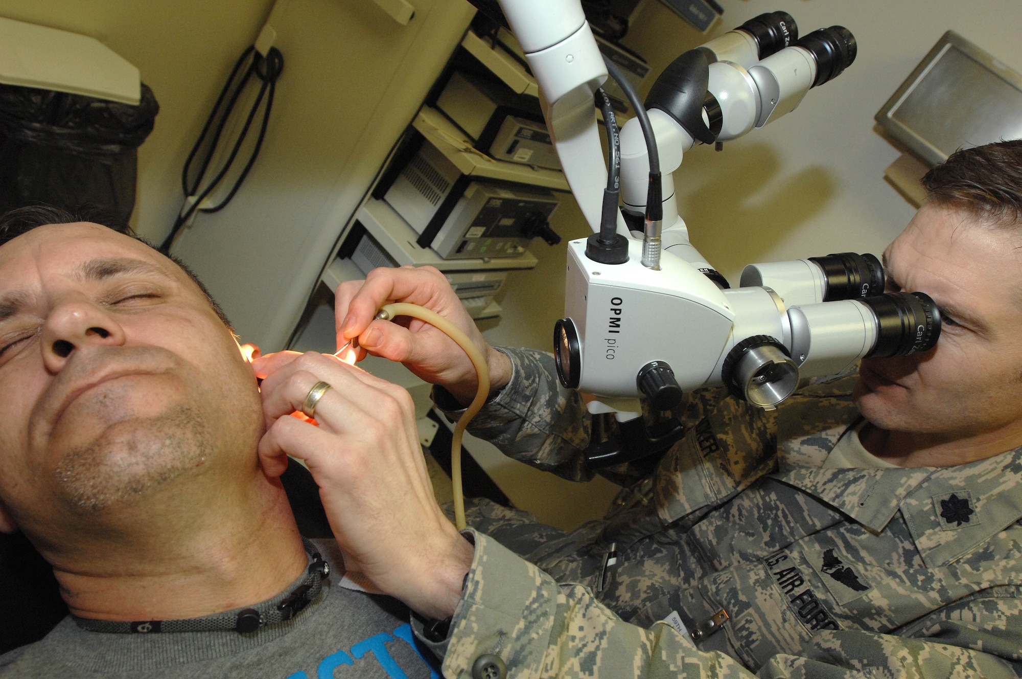 Lt. Col. (Dr.) Mark Packer performs operative care and inspection on U.S. Army Specialist James Tillery?s ears at Wilford Hall Medical Center's Hearing Center of Excellence March 2, 2011, Lackland Air Force Base, Texas. Working to further the medical science, Dr. Packer is the director of the several Department of Defense-directed Centers of Excellence and is an otolaryngologist. Specialist Tillery was injured by an improvised explosive device during a tour in Afghanistan. He is being treated for tympano-mastoidectomy with ossicular reconstruction at Wilford Hall and is currently stationed at Fort Polk, La. (U.S. Air Force photo/Staff Sgt. Robert Barnett)
