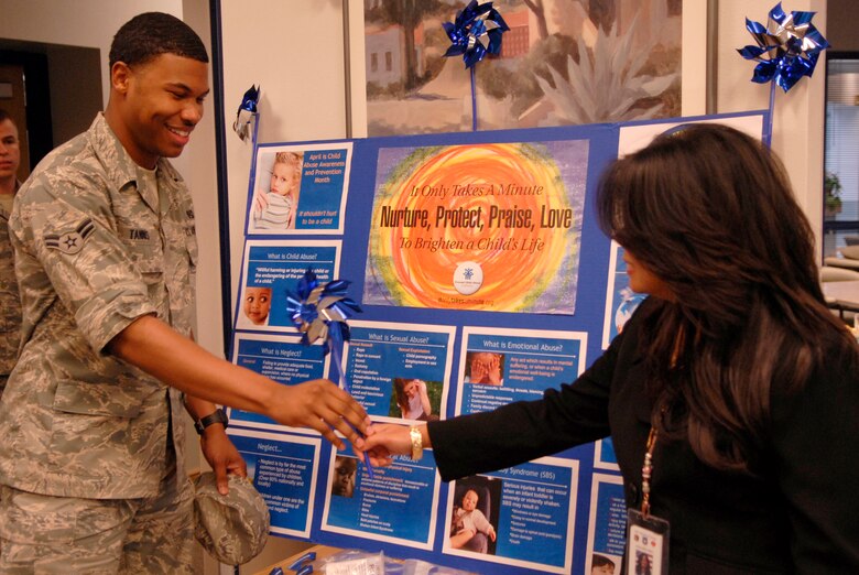 VANDENBERG AIR FORCE BASE, Calif. -- Airman 1st Class Darian Tannis, a 30th Space Wing Judge Advocate member, receives a pinwheel from Pauline Chui, a 30th Medical Operations Squadron program outreach manager, at the dining facility in support of Child Abuse Awareness and Prevention Month here Thursday, April 7, 2011.  Members from Vandenberg's Sexual Assault Prevention and Response office and Family Advocacy displayed their information to educate Team V members.  (U.S. Air Force photo/Staff Sgt. Andrew Satran) 

  