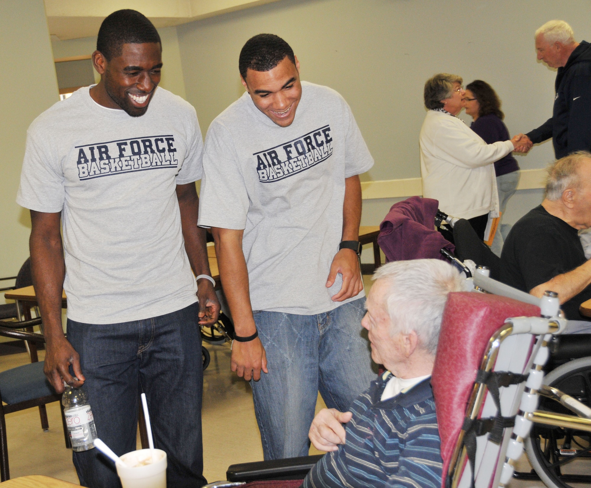 Daniel Nwaelele (left) and Matthew McCraw, Air Force Basketball Team members, visit with Minnesota Vets Home resident Richard Raymond after training camp April 7.  The team is training at Minneapolis-St. Paul Air Reserve station to prepare for the all service championship in San Diego later this week (Air Force Photo/Paul Zadach).