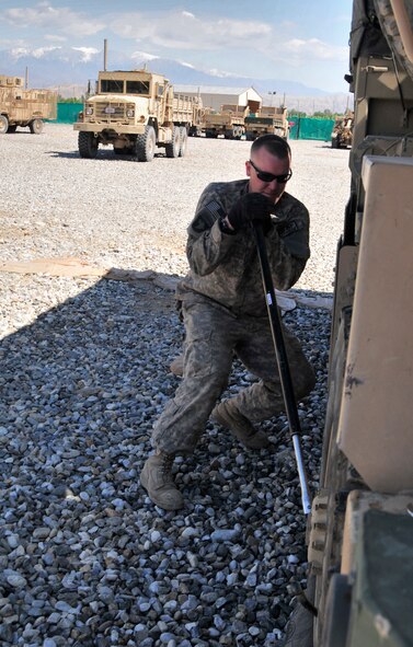 NANGARHAR PROVINCE, Afghanistan--Tech. Sgt. Jason Zollman, Nangarhar Provincial Reconstruction Team vehicle operations NCO in charge, deployed from Moody Air Force Base, Ga., uses a tire iron to remove a flat tire at Forward Operating Base Finley-Shields April 6. The Waterville, Wash., native has been deployed there since October 2010 and spends his time maintaining a 17-vehicle fleet and going on missions as a combat vehicle mechanic. (U.S. Air Force photo/Senior Airman Chanise Epps)(RELEASED)
