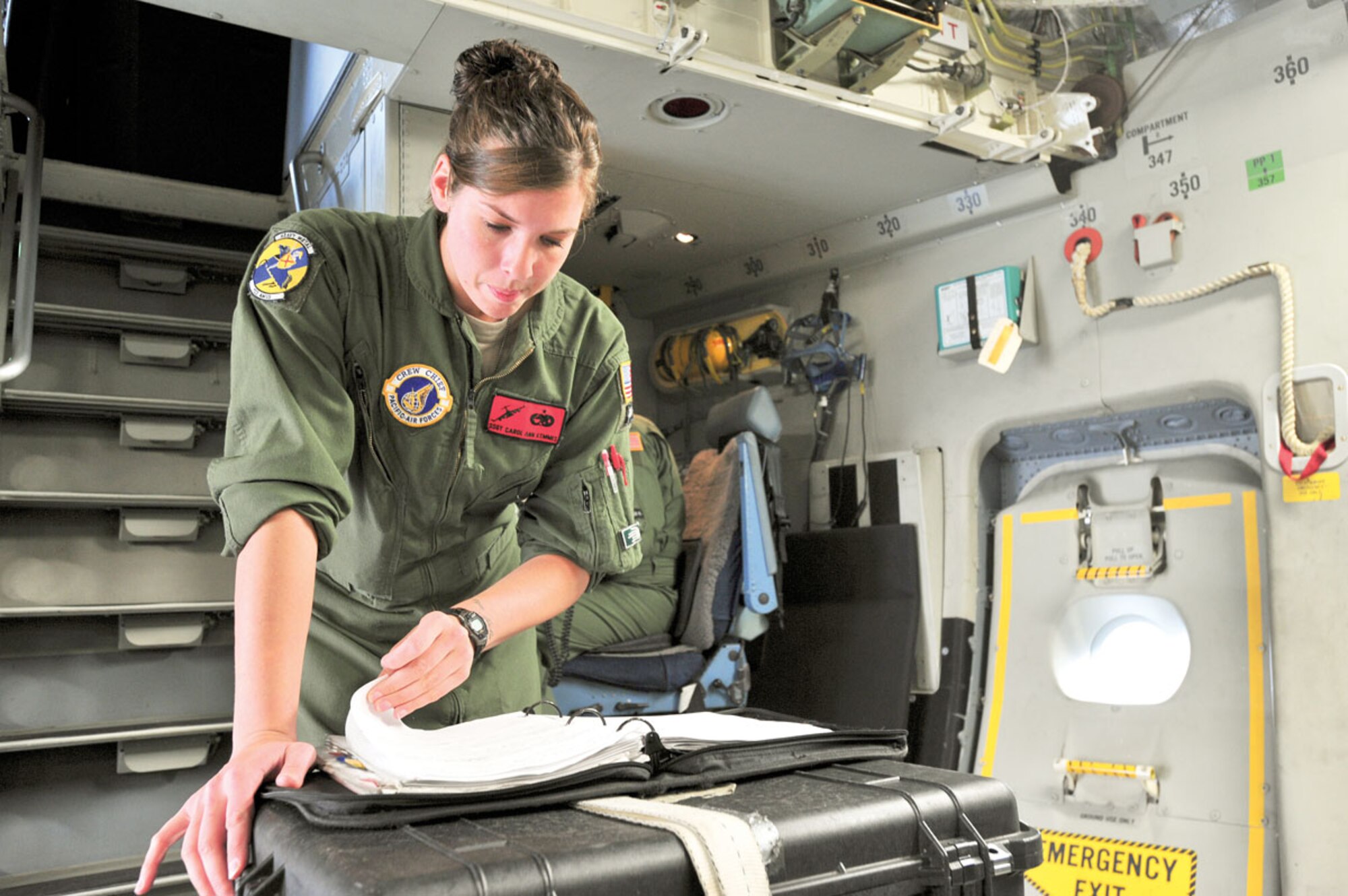 Air Force Staff Sgt. Carol Ann Kemmis, a flight crew chief with the 703rd Aircraft Maintenance Squadron, goes over the maintenance logs of a C-17 Globemaster III prior to a mission At Misawa Air Base, Japan, Saturday. (U.S. Air Force photo/Staff Sgt. Joshua Garcia)
