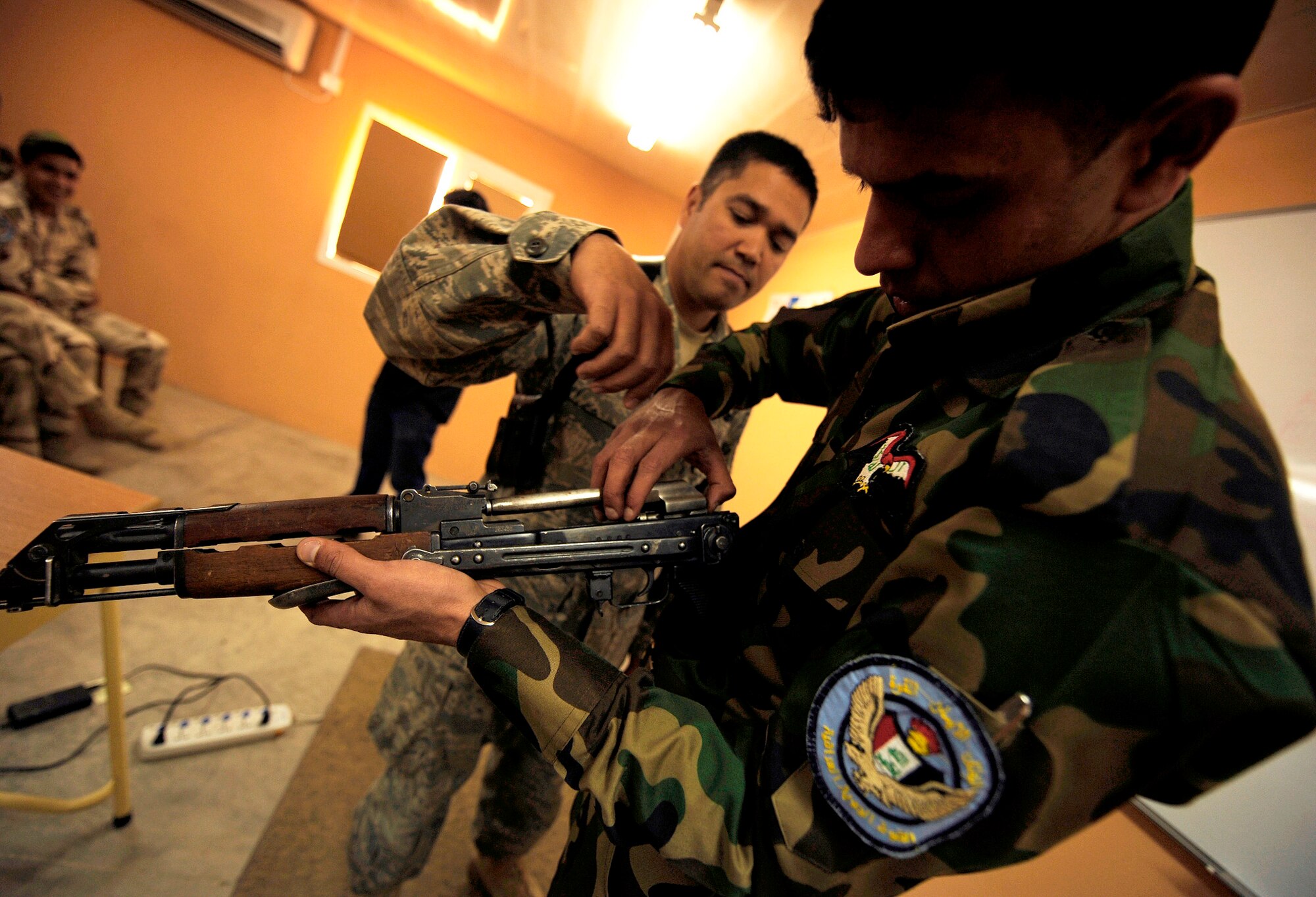 Tech. Sgt. Daniel Delossantos helps an Iraqi airman reassemble an AK-47 rifle during a two-week training course April 5. Sergeant Delossantos is assigned to the 407th Expeditionary Security Forces Squadron. (U.S. Air Force photo/Tech. Sgt. Jason Lake)