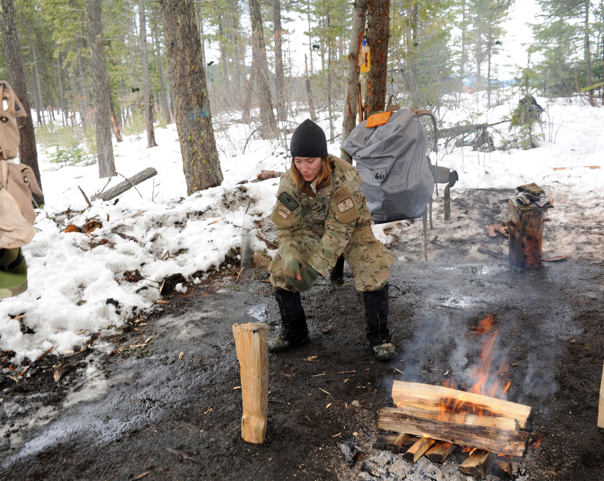 Senior Airman Charlene Plante, a 22nd Training Squadron survival, evasion, resistance and escape instructor at Fairchild Air Force Base, Wash., chops wood for a fire for her students March 13, 2011, in Colville National Forest, Wash. The fire will ensure her students have the capability of drying their wet clothes and provide much-needed warmth. Airman Plante will use this time to check her students for frostbite as a safety precaution. (U.S. Air Force photo illustration/Tech. Sgt. JT May III) 
