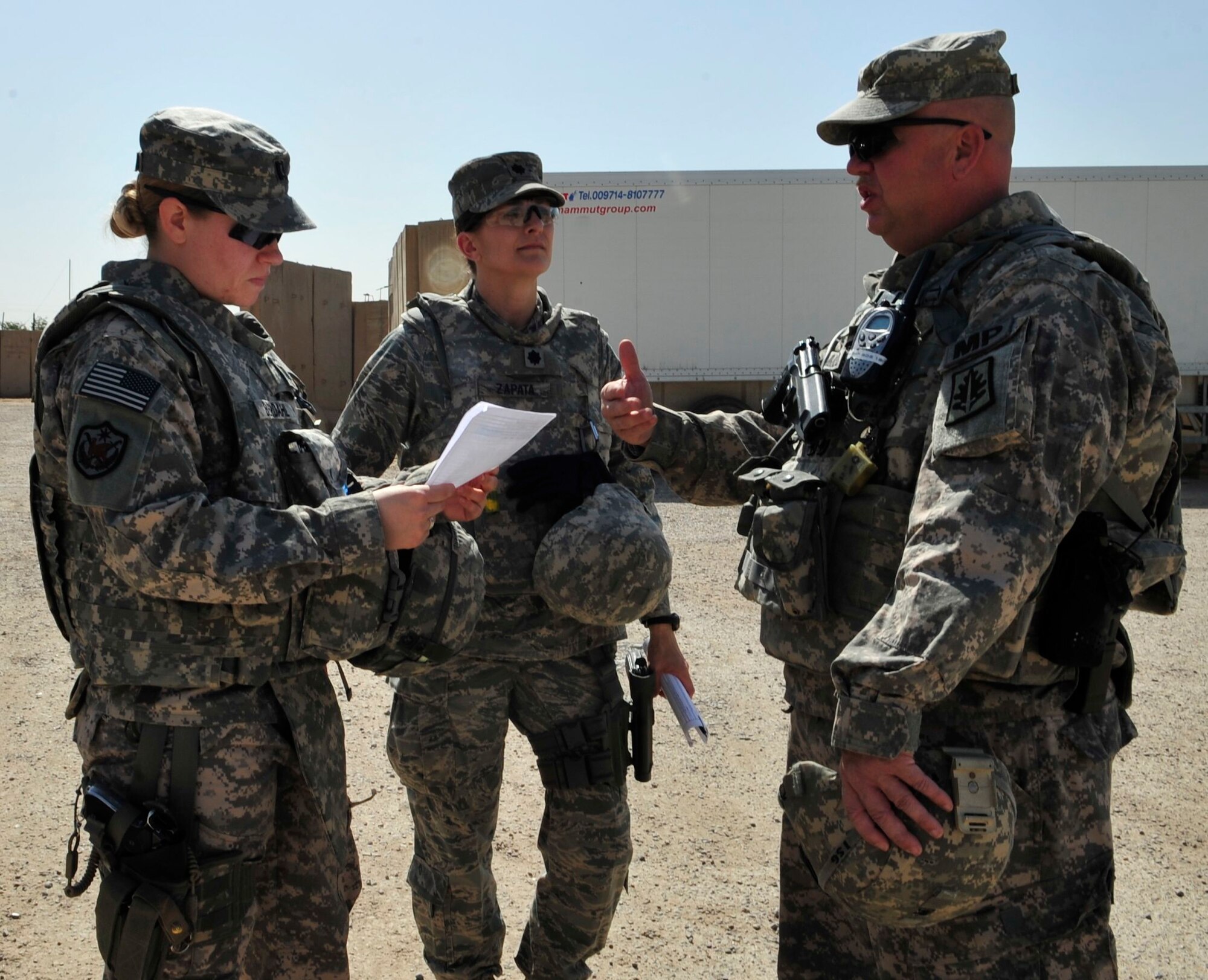 From left to right, U.S. Army Capt. Kristen Berdahl, U.S. Air Force Lt. Col. Kaylin Haywood Zapata and U.S. Army 1st Sgt. Ed Hammond discuss preparation for a mission at Joint Security Station Shield, Iraq, April 6, 2011. Before going outside-the-wire to assess the conditions at a women’s prison in Baghdad’s Rusafa District, these members of the corrections assistance transition team go over checklists of questions they will ask Iraqi officials at the facility. (U.S. Air Force photo by Senior Master Sgt. Larry A. Schneck/Released)