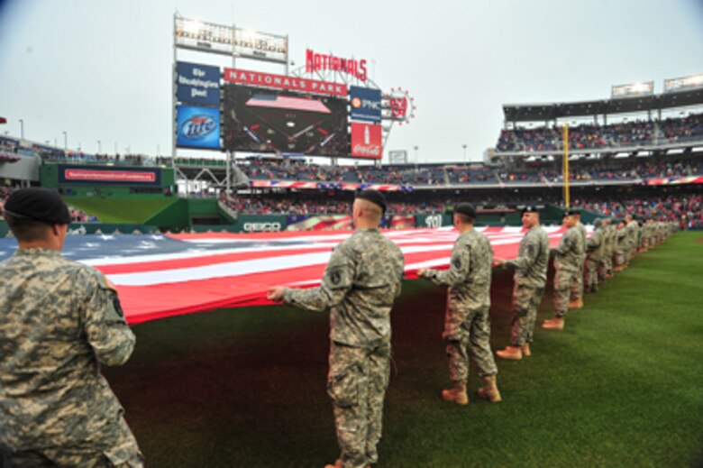 Members of the D.C. National Guard hold a football-field sized American flag on the outfield during pre-game ceremonies for Opening Day at Nationals Park in Washington, D.C. March 31, 2011. U.S. Air Force Photo by Tech. Sgt. Tyrell Heaton 