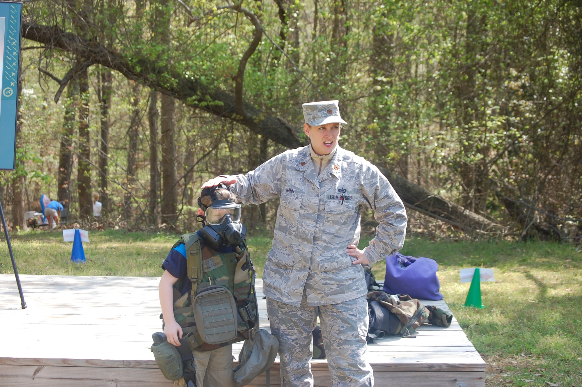 Maj. Shannon Mann talks to a group of students at Cooper Elementary School during their Community Day. One student was brave enough to try on parts of the chemical gear ensemble. (USAF photo by Capt. Jessica Guarini, 911ARS)