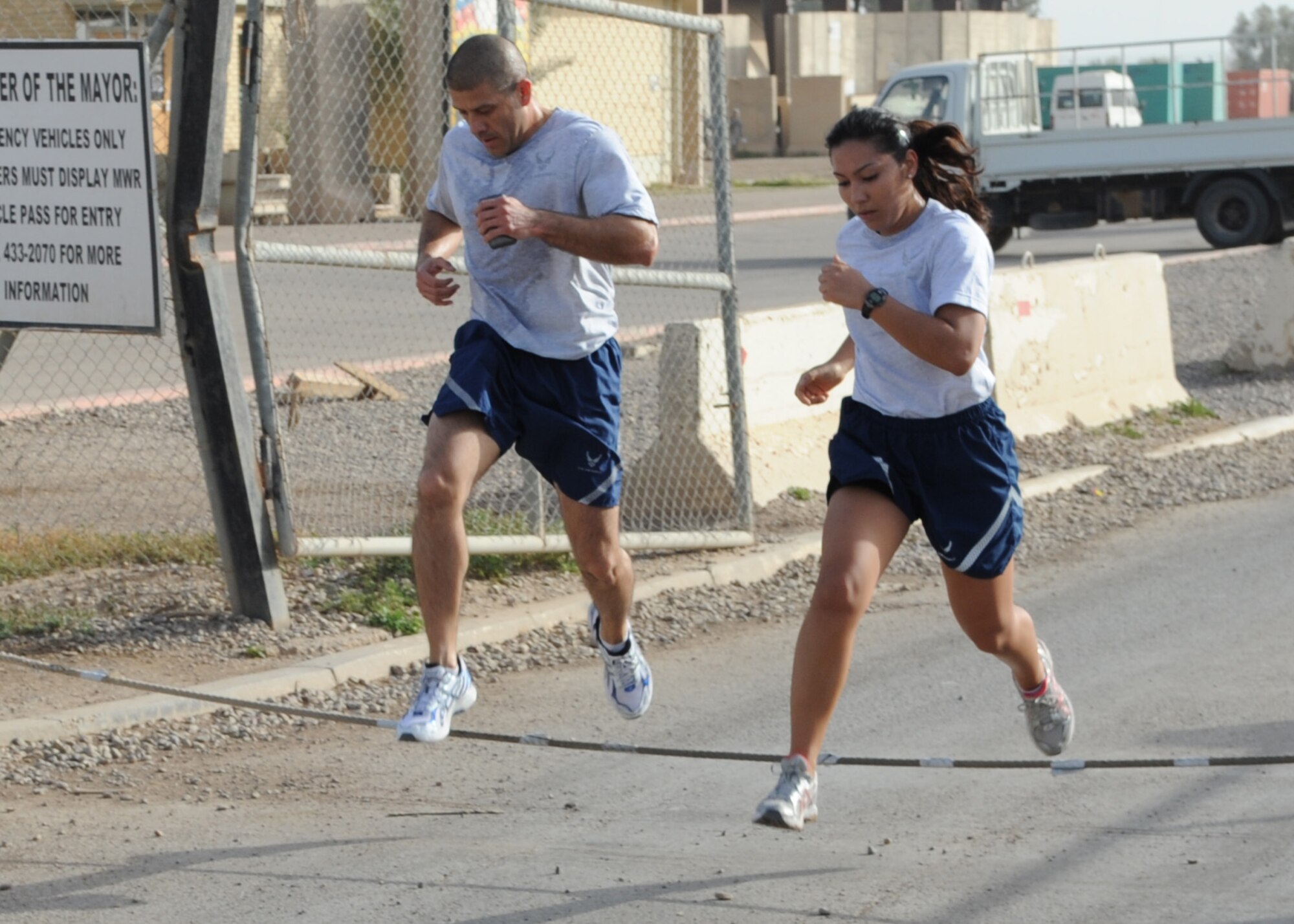 JOINT BASE BALAD, Iraq--Master Sgt. Juan Salazar, left, and Senior Airman Anastacia Barela, right, 332nd Expeditionary Medical Operations Squadron medical technicians, run to their next obstacle during the Fittest Fighter challenge April 9, 2011. The Fittest Fighter competition is designed to promote healthy fitness and nutritional lifestyles. The 40 participants lost 357.2 pounds. (U.S. Air Force photo/ Staff Sgt. Keyonna Fennell)
