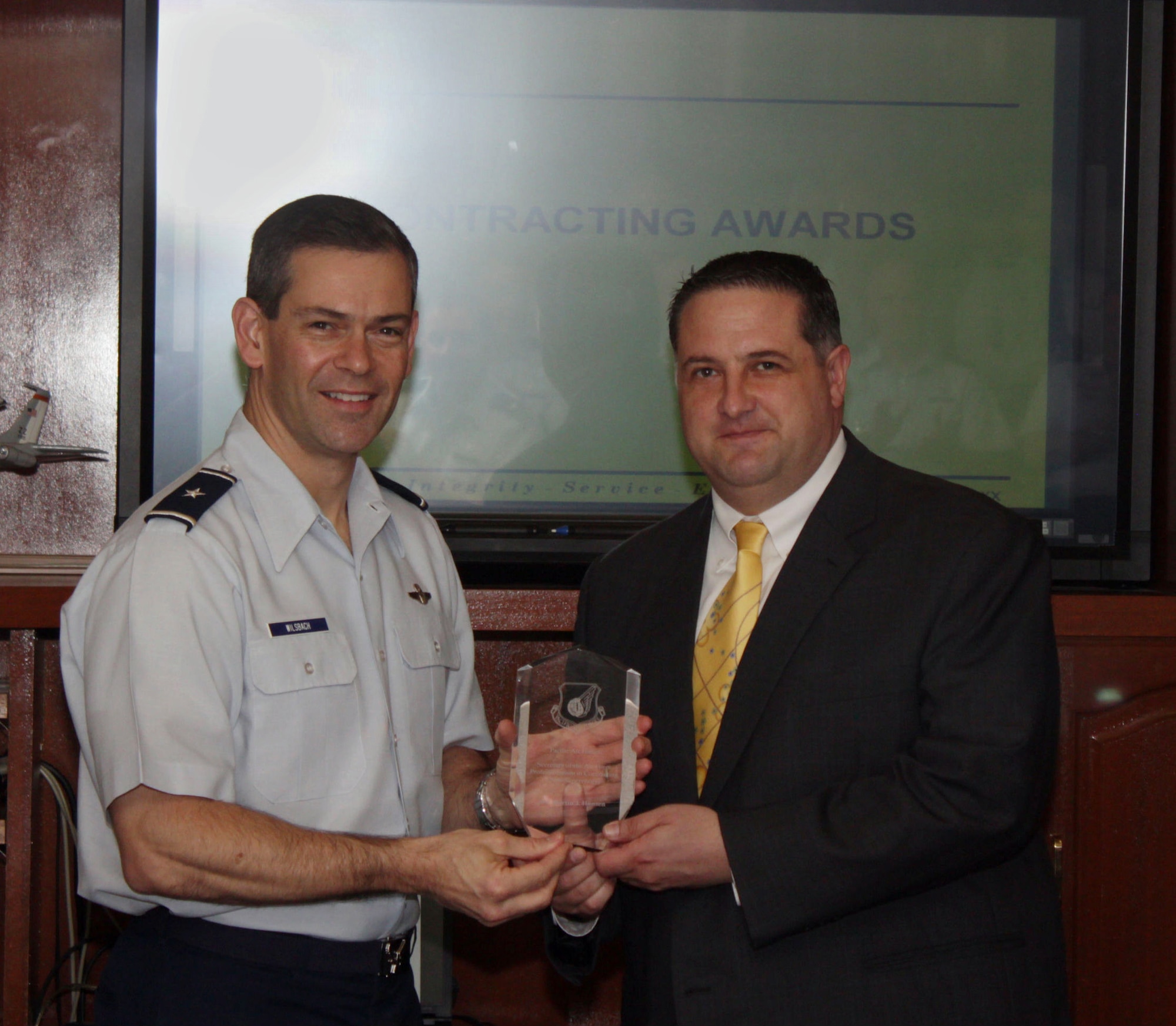 Martin Hansen, the Infrastructure Acquisition flight chief, receives the Secretary of the Air Force Professionalism in Contracting (non-supervisory) award from Brig. Gen. Ken Wilsbach, the 18th Wing commander, here at Kadena Air Basae, March 21. This was one of five individual awards the contracting squadron received. The 18th CONS was also named Outstanding Large Contracting Unit in the Pacific Air Force. (U.S. Air Force photo/Senior Airman George Halley)