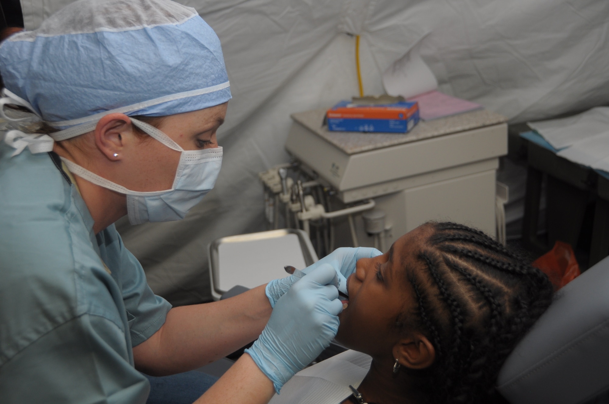 U.S. Air Force Staff Sgt. Jamie Dillon, 60th Medical Group dental technician, prepares Kennille Duncan, 11, for dental work at Cumuto Barracks in Trinidad and Tobago April 10, 2011.  Patients traveled from all regions of Trinidad and Tobago to receive care from the Health Response Team (U.S. Air Force photo by 2d Lt Joel Banjo-Johnson/Released)
