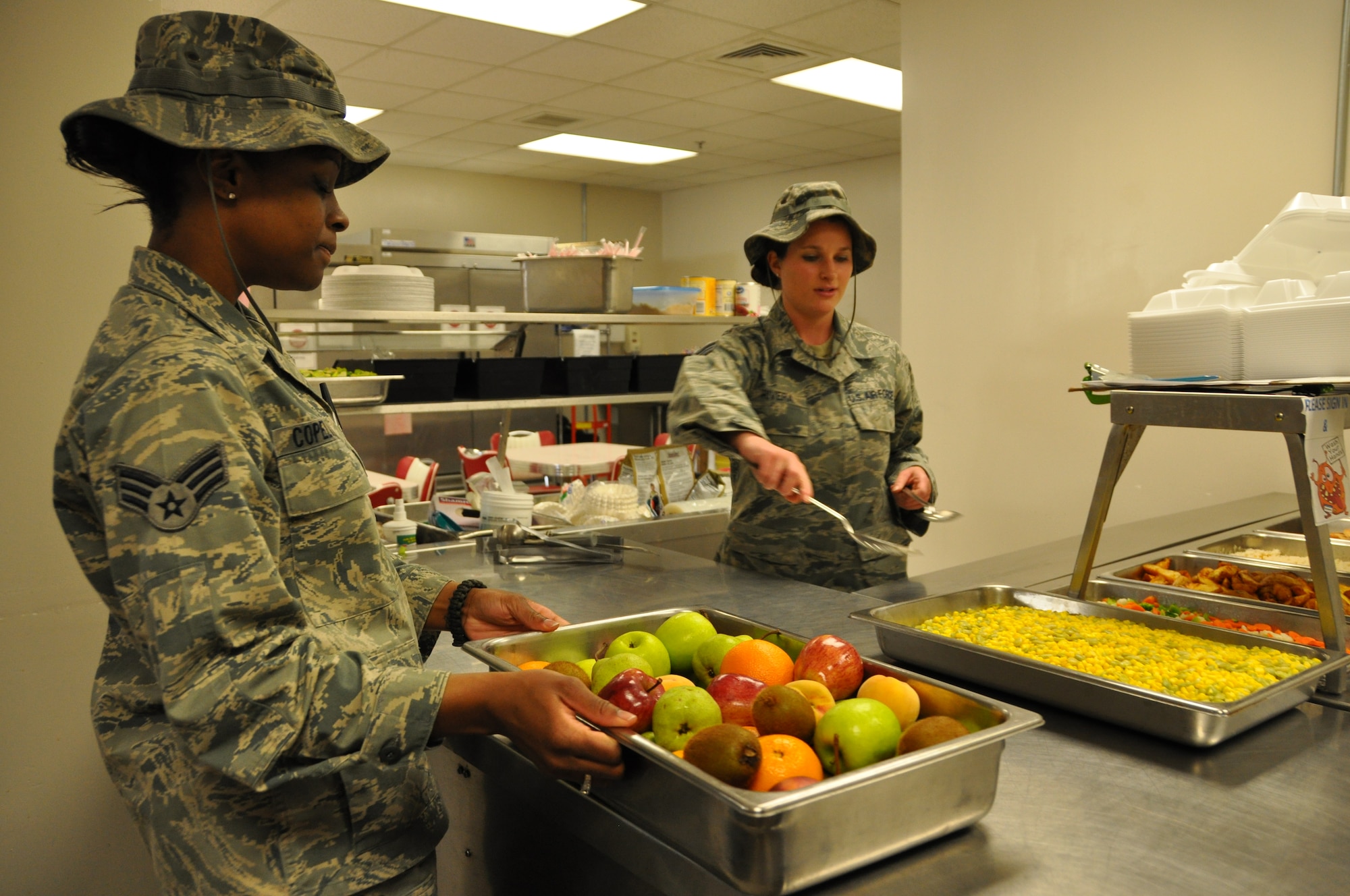 Senior Airman Latrice Copeland and Senior Airman Mollie Rivera, 60th Medical Diagnostics and Therapeutics Squadron diet therapy technicians, carefully prepare lunchtime meals for hospital patients, their guardians and their families in the Nutritional Medicine Flight Apr 9.