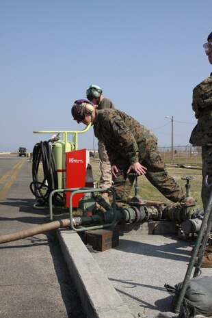 Lance Cpl. Adam Cashin, Marine Wing Support Squadron 171 bulk fuel specialist, turns the fuel open while checking the pressure as a Marine All-Weather Fighter Attack Squadron 533 F/A-18 Hornet is refueled. Without the fuel bulk fuel specialists provide, aircraft arriving and departing the air station would be unable to complete missions.