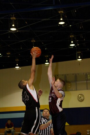 Christopher Flores, IYAOYAS center, snatched the toss up from Kyle Strausbach, G-SUPP center during a 2011 Intramural Basketball Season game at the IronWorks Gym sports courts here April 12. Strausbach and the other G-SUPP players proved they owned the court with a 56-25 win.