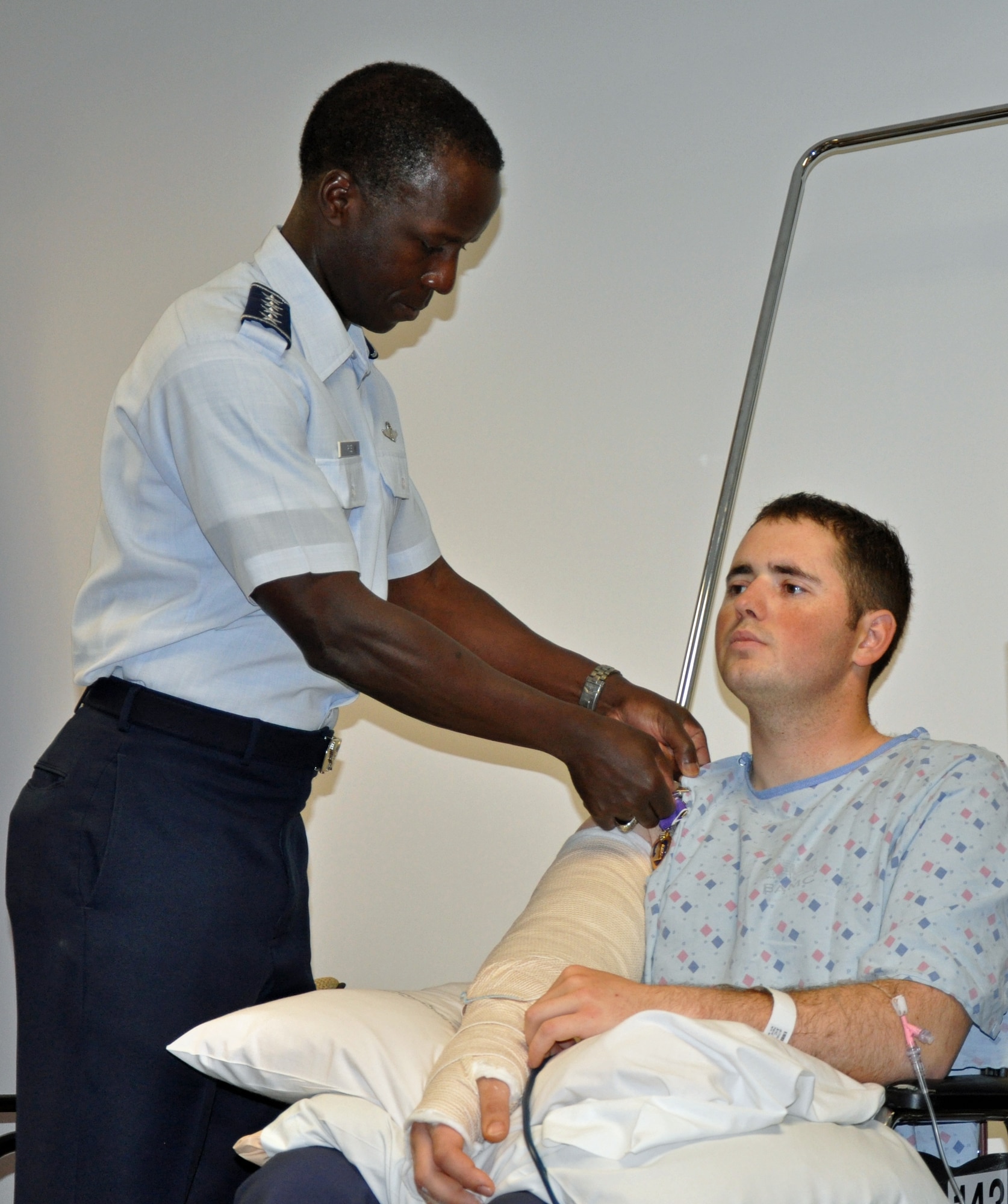RANDOLPH AIR FORCE BASE, Texas - Senior Airman Erik Schadler, 21st Civil Engineer Squadron, receives the Purple Heart Medal and the Air Force Combat Action Medal from Gen. Edward Rice Jr., Air Education and Training Command commander, April 6 at Brooke Army Medical Center, San Antonio. Airman Schadler received the medals for wounds received in combat action against a hostile enemy force in Afghanistan. Airman Schadler is an explosive ordnance disposal specialist, and was wounded in action while taking part in Operation Enduring Freedom March 21 in Afghanistan. (U.S. Army photo/Russell Fritz)