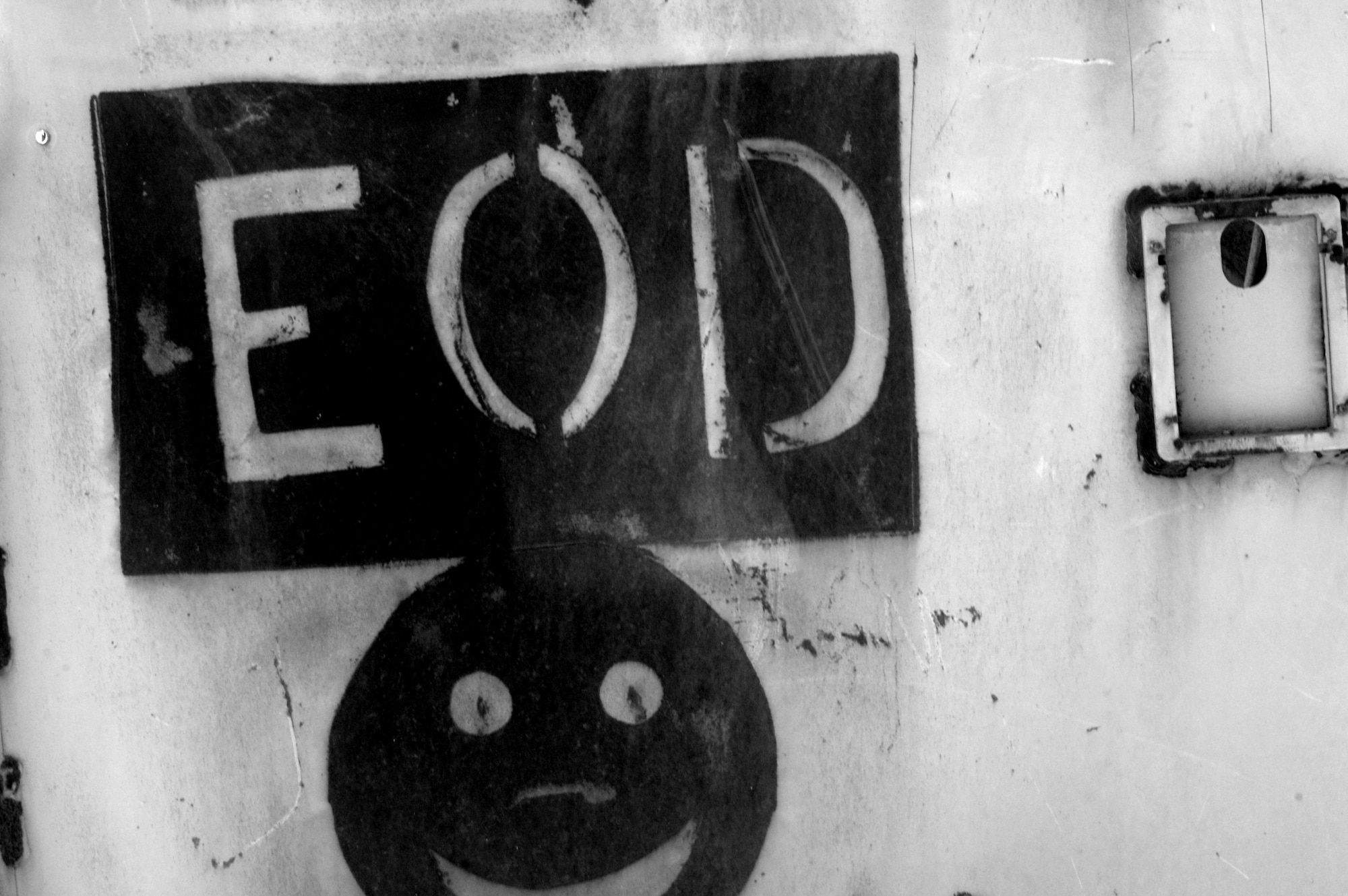 An explosive ordnance disposal logo is painted on an old vehicle door at one of the ranges on Ali Air Base, Iraq. U.S. Army and Air Force EOD technicians save money by disposing of unserviceable ammunition on base as opposed to shipping it back to the U.S. (U.S. Air Force photo/Staff Sgt. R. Michael Longoria)