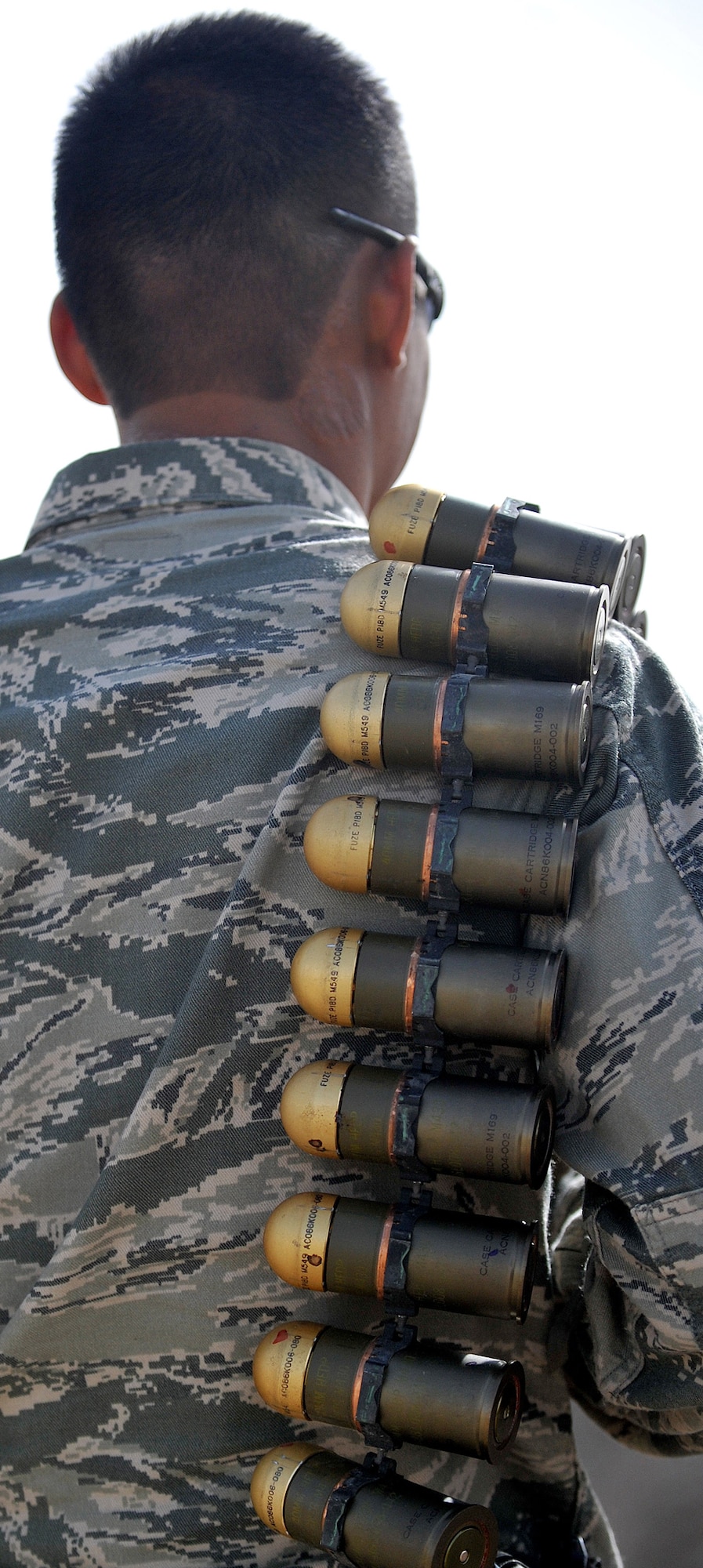 Senior Airman Jesse Mercado carries a link of 40-millimeter rounds on his shoulder to add to the pile of ammunition for detonation March 3, 2011, at Ali Air Base, Iraq. Airman Mercado is an explosive ordnance disposal technician assigned to the 407th Expeditionary Operations Support Squadron. (U.S. Air Force photo/Senior Airman Andrew Lee) 