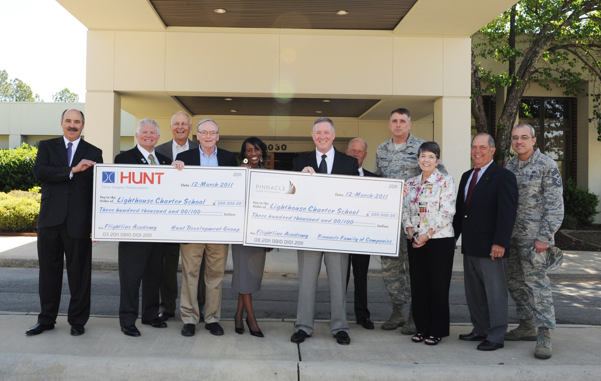 (From left) Robin Vaughn of Hunt; Phil Davis, Larry Biernacki, Mike Ronan, Phillis Anderson; Mike Rouen of Pinnacle; Mike Wilson, Col. Mike Minihan, 19th Airlift Wing commander; Kathy Wilson Roberts, Larry Wilson, and Chief Master Sgt. James Morris, 19th Airlift Wing command chief, pose for group photo April 12, 2011, at the Flightline Academy at Little Rock Air Force Base, Ark. Hunt and Pinnacle each pledged $300k toward the establishment of a Lighthouse Academies middle school. (U.S. Air Force photo by Airman 1st Class Ellora Stewart)