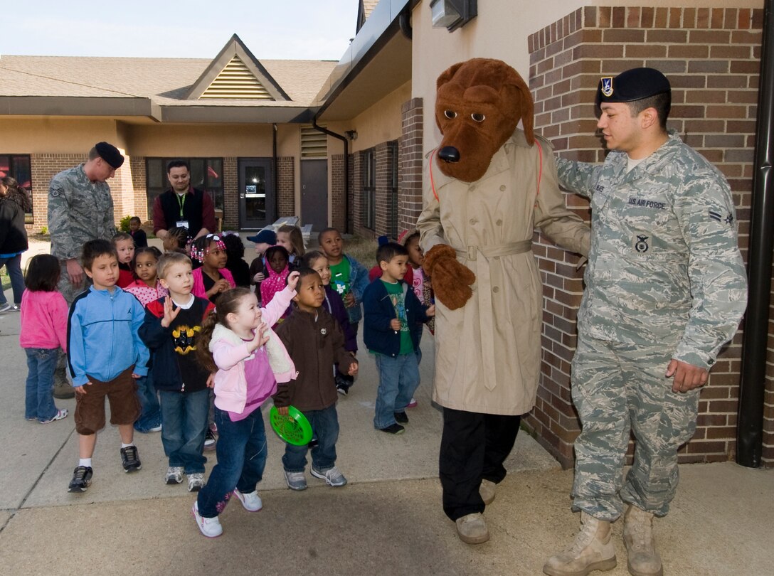 A group of Child Development Center II children wave goodbye to McGruff the Crime Dog and Airman 1st Class Timothy Shears, 11th Security  Forces Squadron police services, during the kick off observance of Month of the Military Child April 8. (Photo by Bobby Jones)