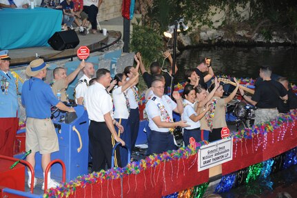 Military ambassadors wave to the crowd as they pass on their float during the Fiesta River Parade on the San Antonio River Walk April 11. Fiesta is an annual two-week celebration held in San Antonio. (U.S. Air Force photo/David Terry)