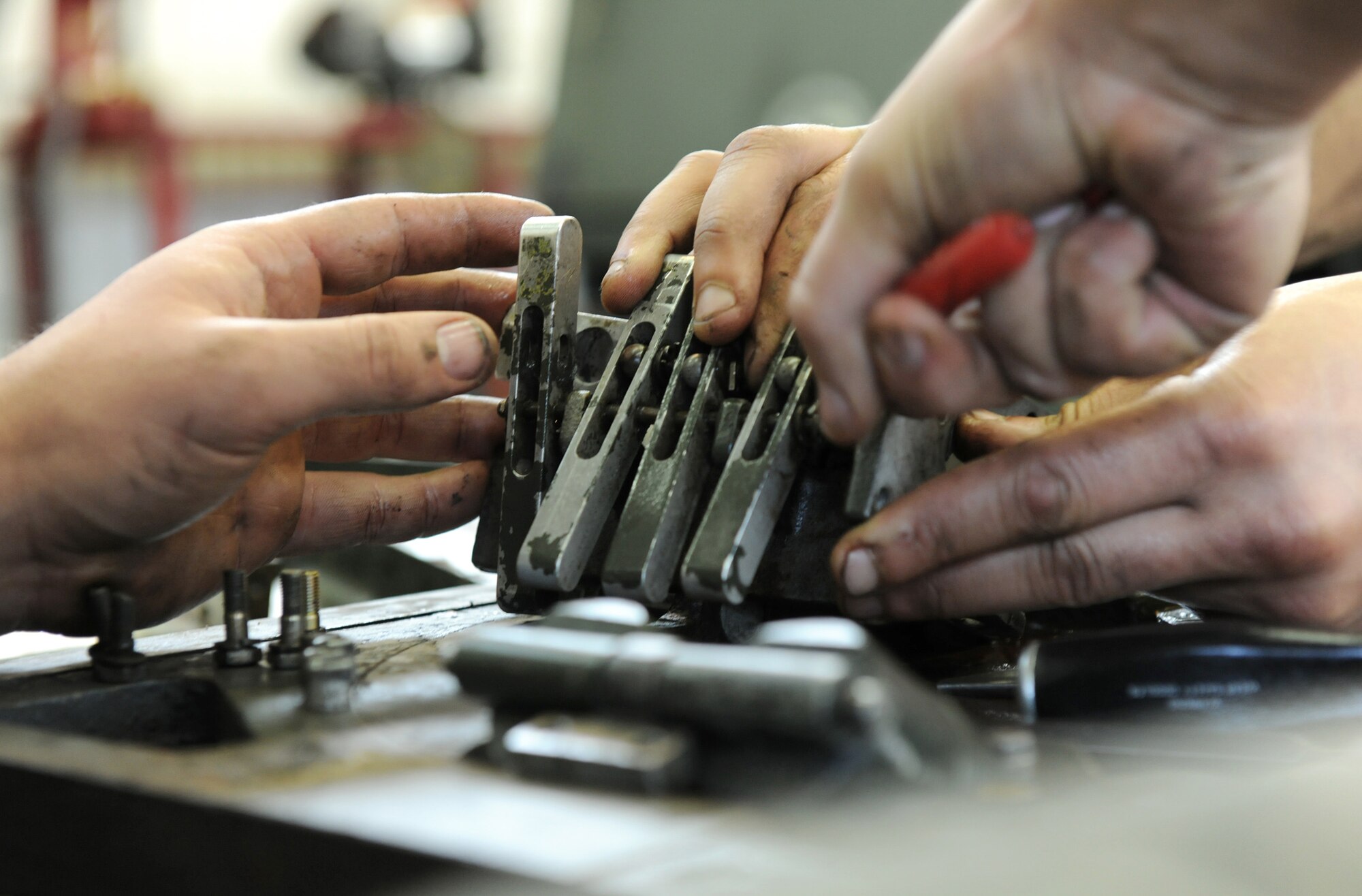 Aerospace ground equipment journeymen assigned to the 52nd Equipment Maintenance Squadron unscrew bolts holding a directional control valve together on a bomb lift April 7, 2011, at Spangdahlem Air Base, Germany. (U.S. Air Force photo/Senior Airman Nathanael Callon)