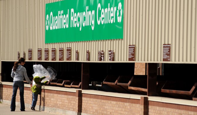 WHITEMAN AIR FORCE BASE, Mo. -- Jennifer Weber, wife of 1st Lt. Christopher Weber, 509th Medical Support Squadron and son Gabe Weber recycle plastic at Whiteman’s Recycling Center April 11, 2011. Airmen and their families using the recycling center can help save thousands of dollars by keeping trash companies from having to pick up the waste while also helping the Air Force stay eco-friendly. (U.S. Air Force photo by Senior Airman Kenny Holston)(Released)

